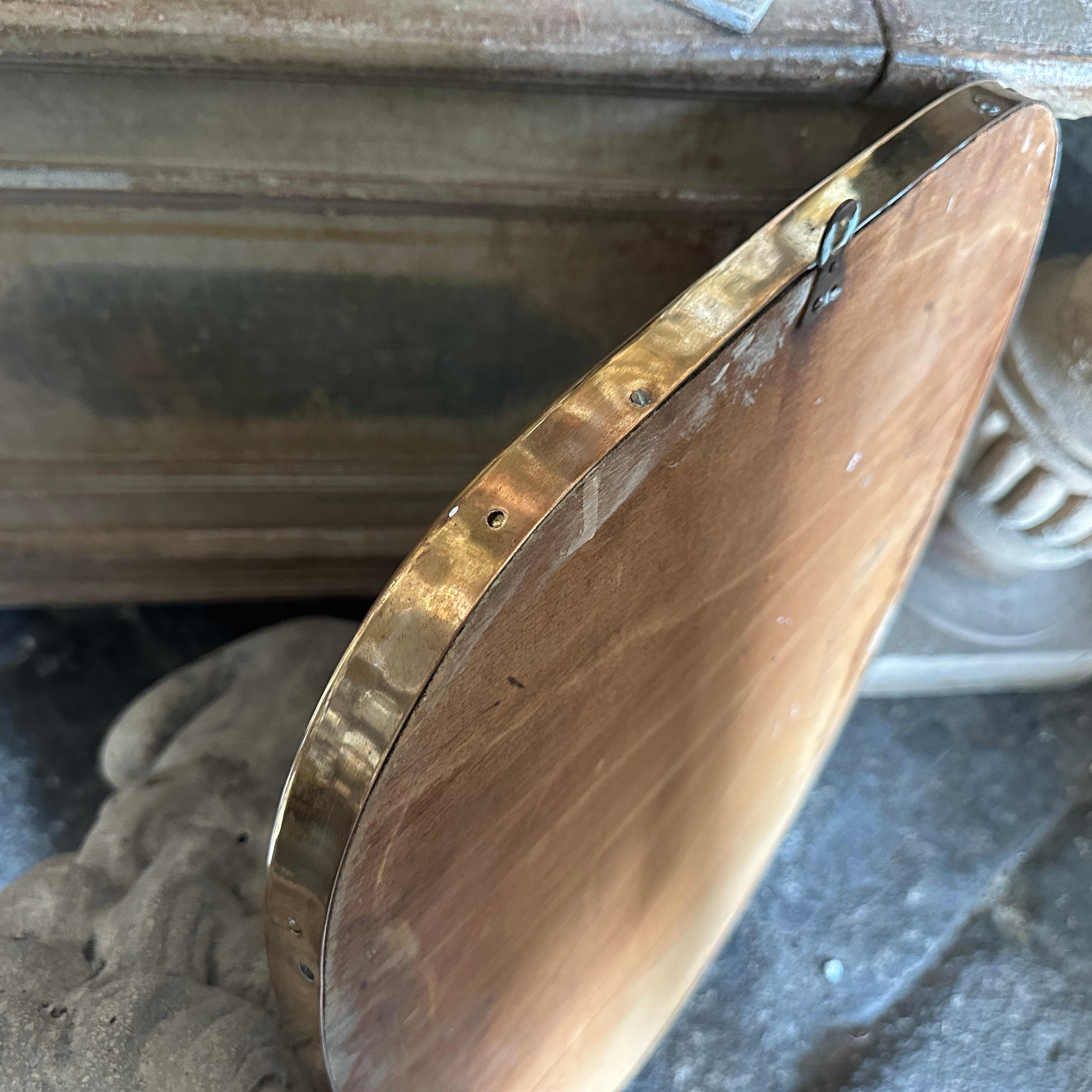 Uno specchio da parete in ottone massiccio progettato e realizzato in Italia alla maniera di Gio Ponti, che utilizzava questo tipo di specchio nelle più belle case milanesi degli anni '50. L'ottone vanta una bella patina originale, mentre il vetro