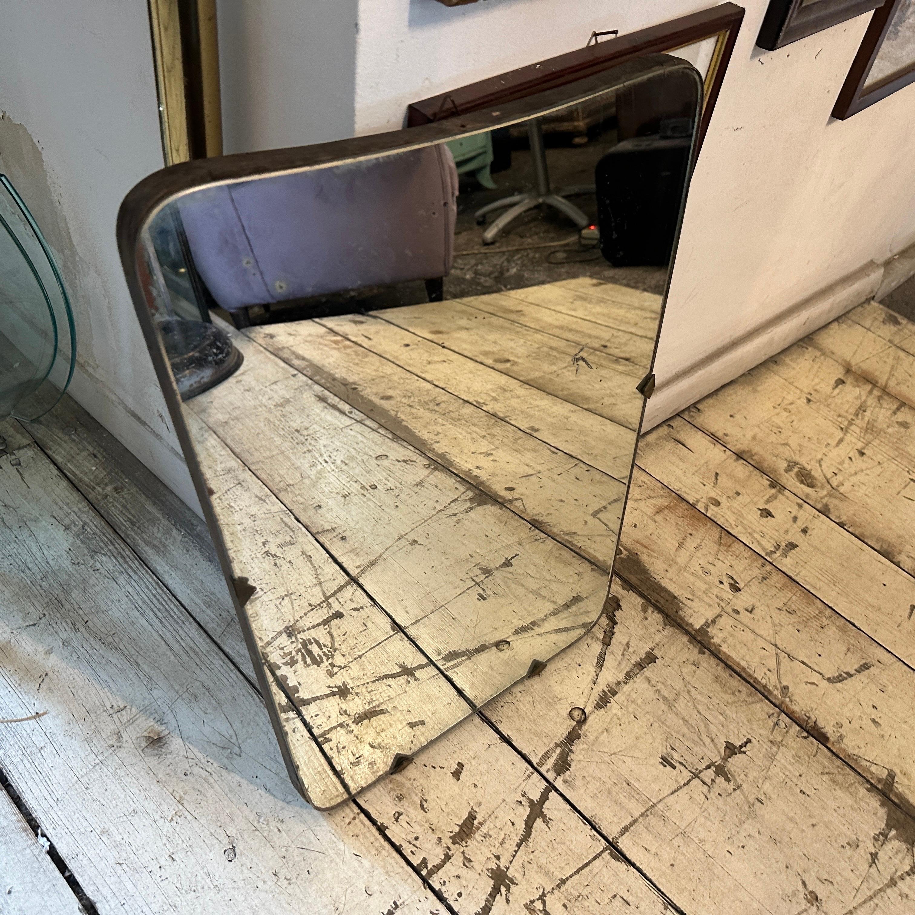 An original Mid-Century Modern well shaped wall mirror designed and manufactured in Italy in the Fifties. In the manner of Gio Ponti, whose wall mirrors furnished the most prestigious homes in Milan in the 1950s. This Wall Mirror is a stunning and