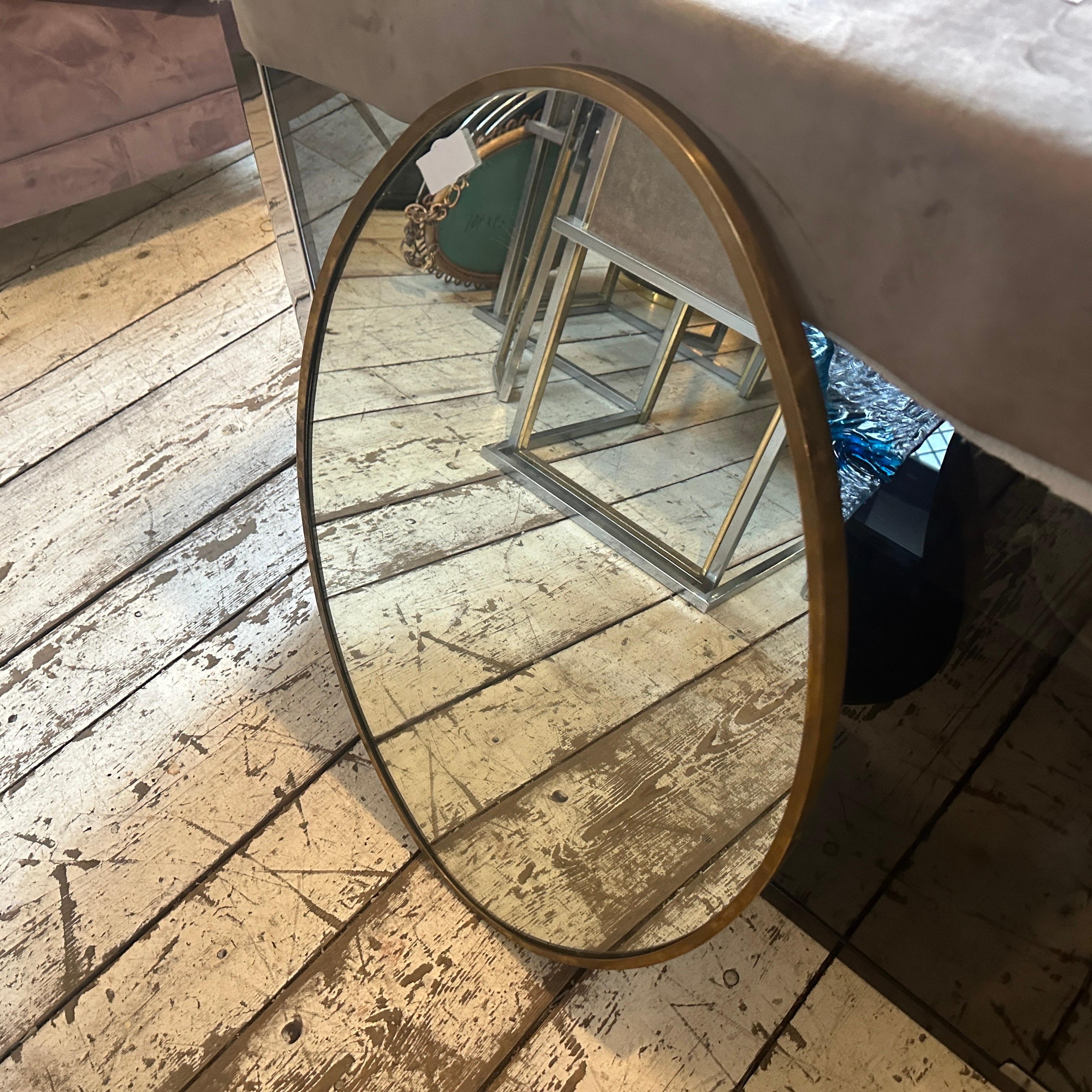 Miroir mural en laiton massif conçu et fabriqué en Italie dans les années 50, le laiton est en patine d'origine et présente de petits signes d'utilisation et d'âge, le verre du miroir est celui d'origine. Les années 1950 ont été une période de
