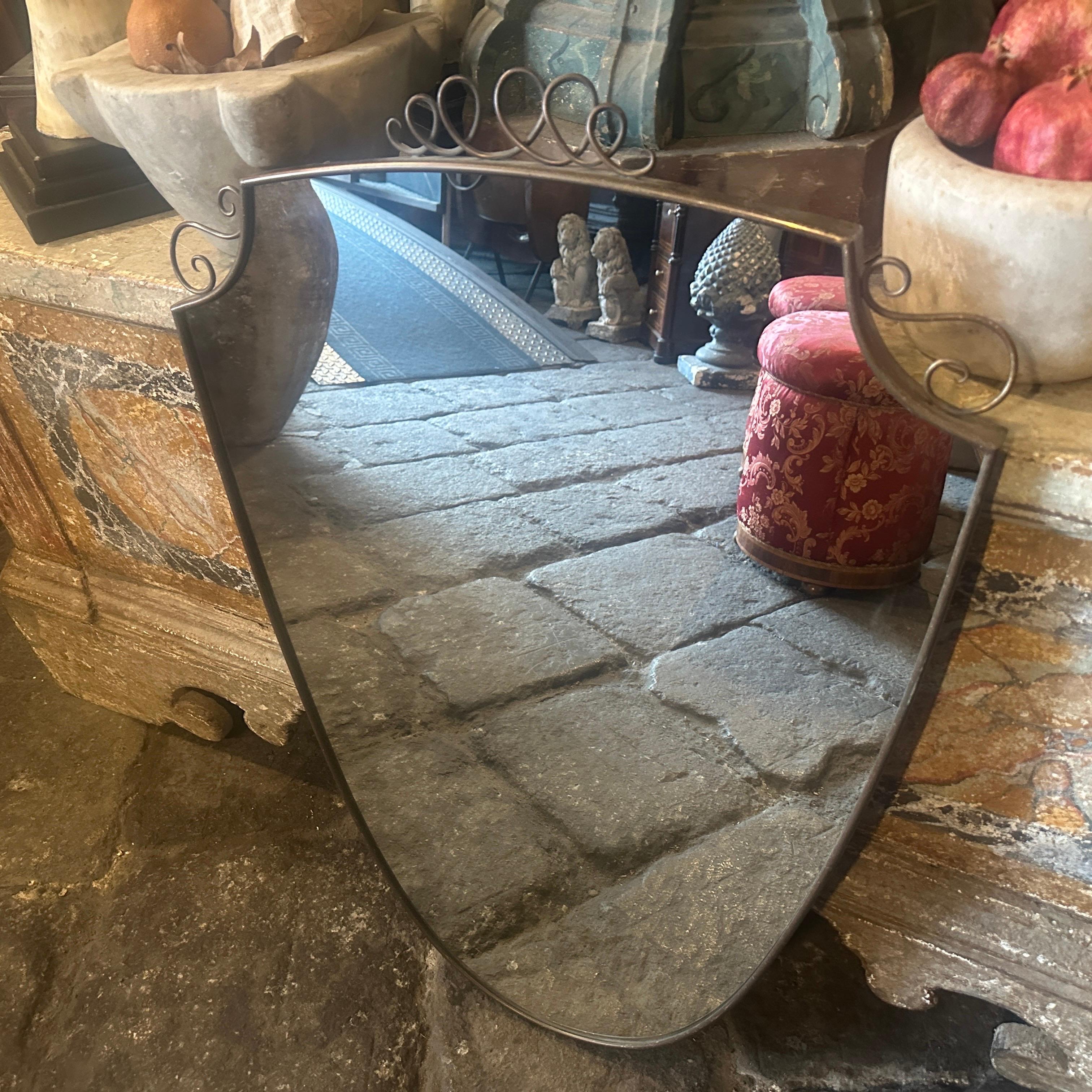 Un asombroso espejo de pared de latón macizo con forma de escudo moderno de mediados de siglo, fabricado a mano en Italia en los años cincuenta a la manera de Gio Ponti, que utilizaba estos espejos de pared para amueblar las casas más prestigiosas