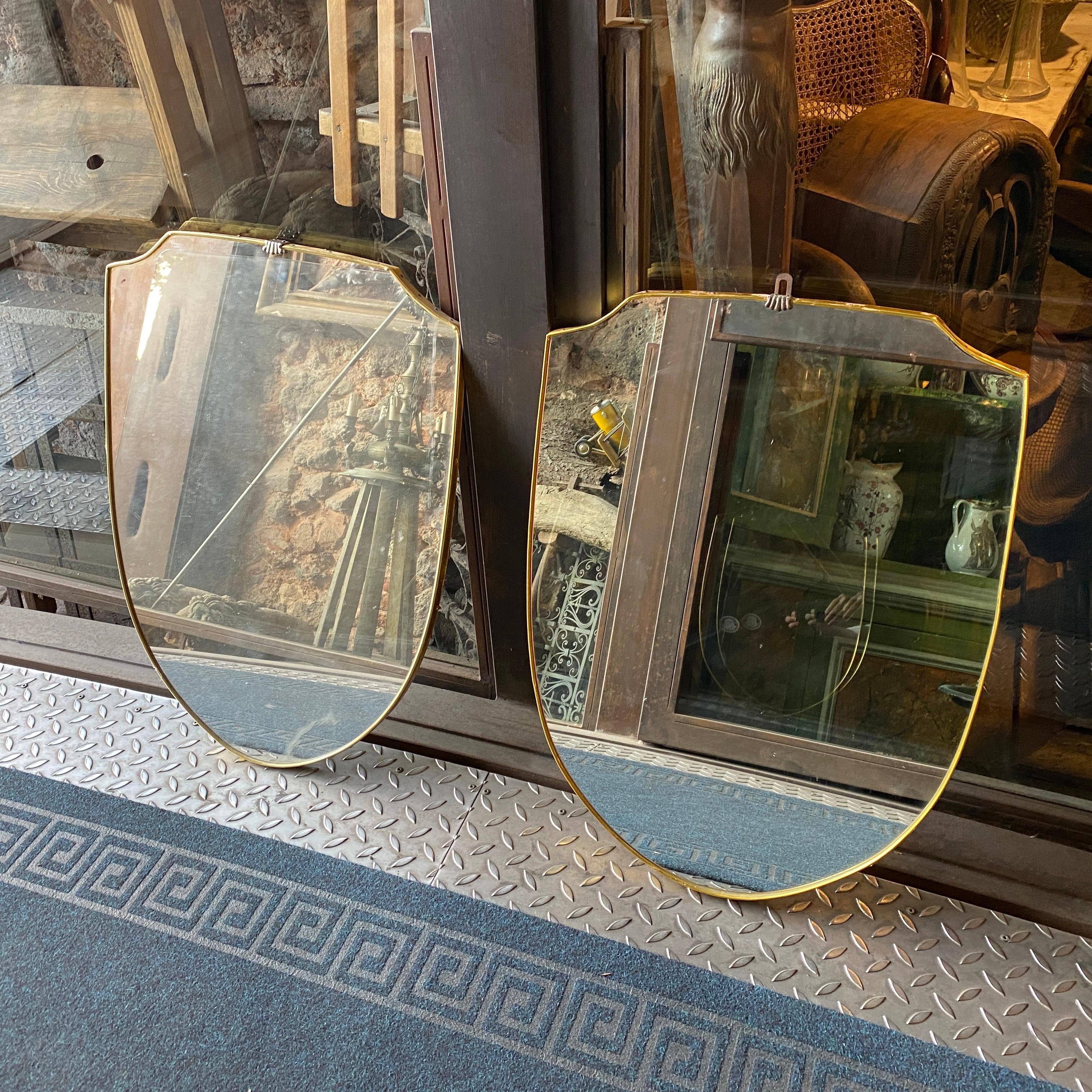 Two shield wall mirrors made in Italy in the fifties in the manner of Giò Ponti. Signs of the age.