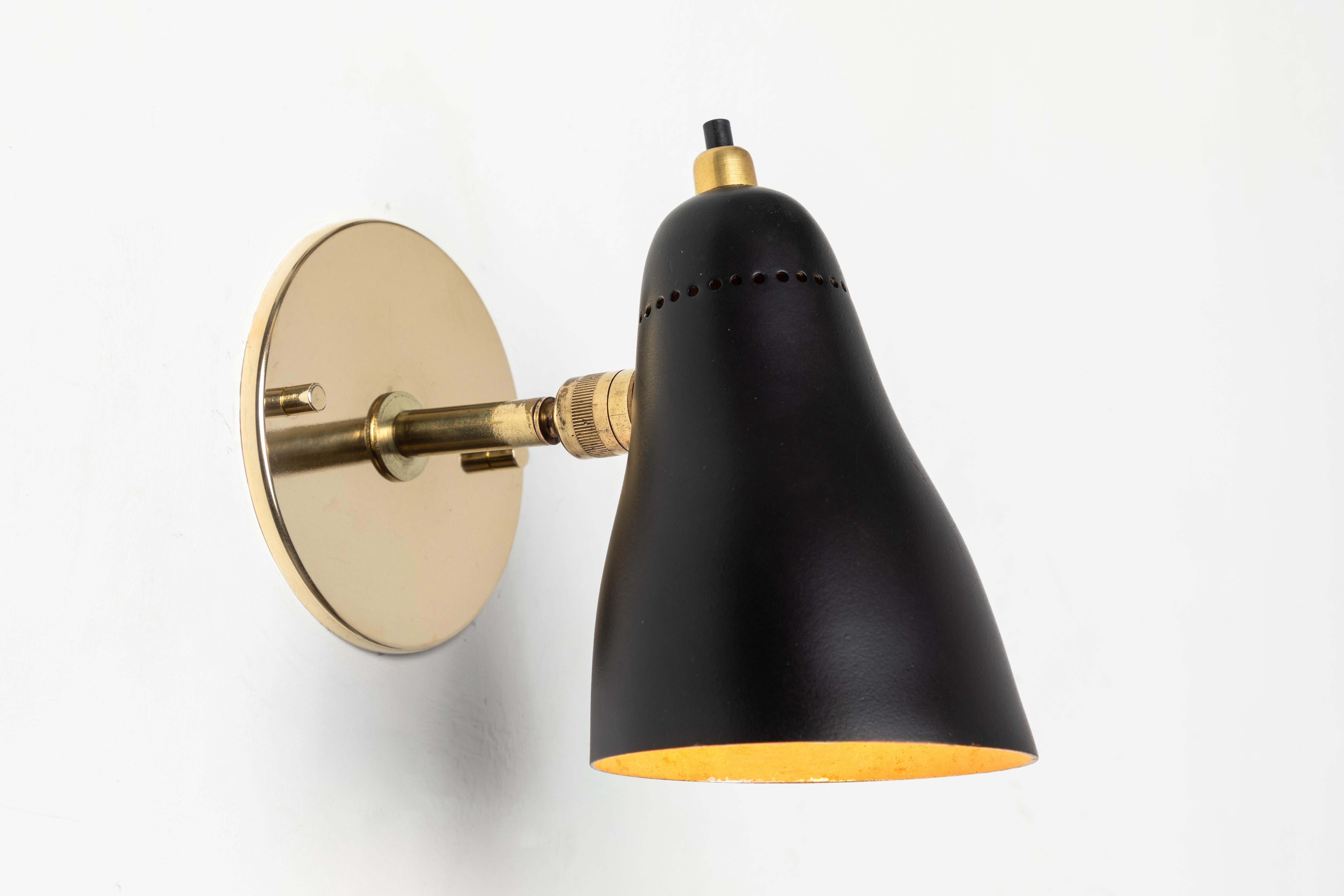 1950s Giuseppe Ostuni articulating sconce for O-Luce. Executed in brass and painted aluminum with perforated shade. Sconce pivots up/down and left/right on two separate ball joints. Original on/off switch on top of lamp. Wired for US electrical