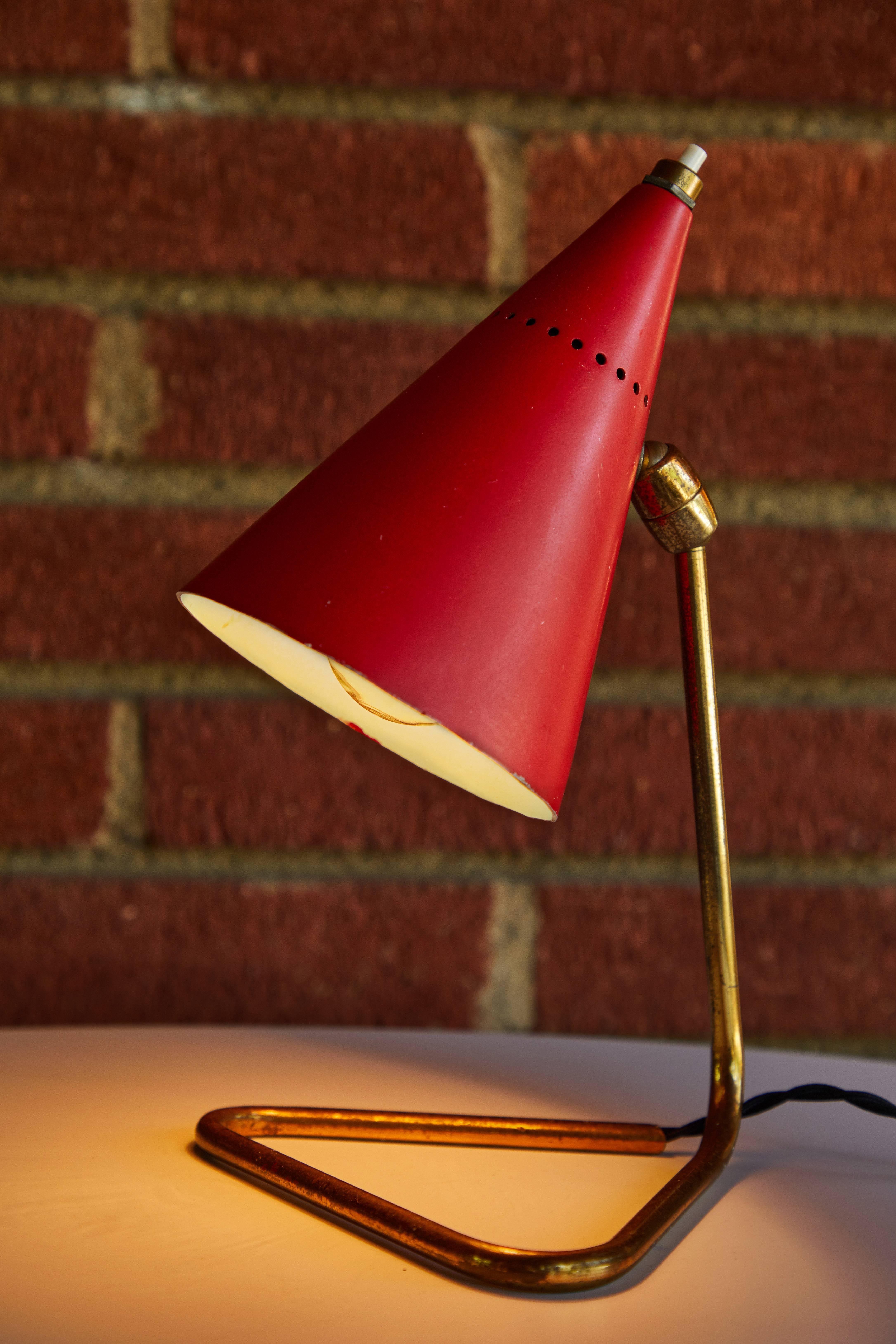 1950er Jahre Giuseppe Ostuni Rote Kegel-Tischlampe für Oluce. Dieses zierliche klassische Design ist in leicht patiniertem Messing und rot lackiertem Metall mit Originalfarbe in gutem Vintage-Zustand ausgeführt. Der Schirm ist an zwei Punkten