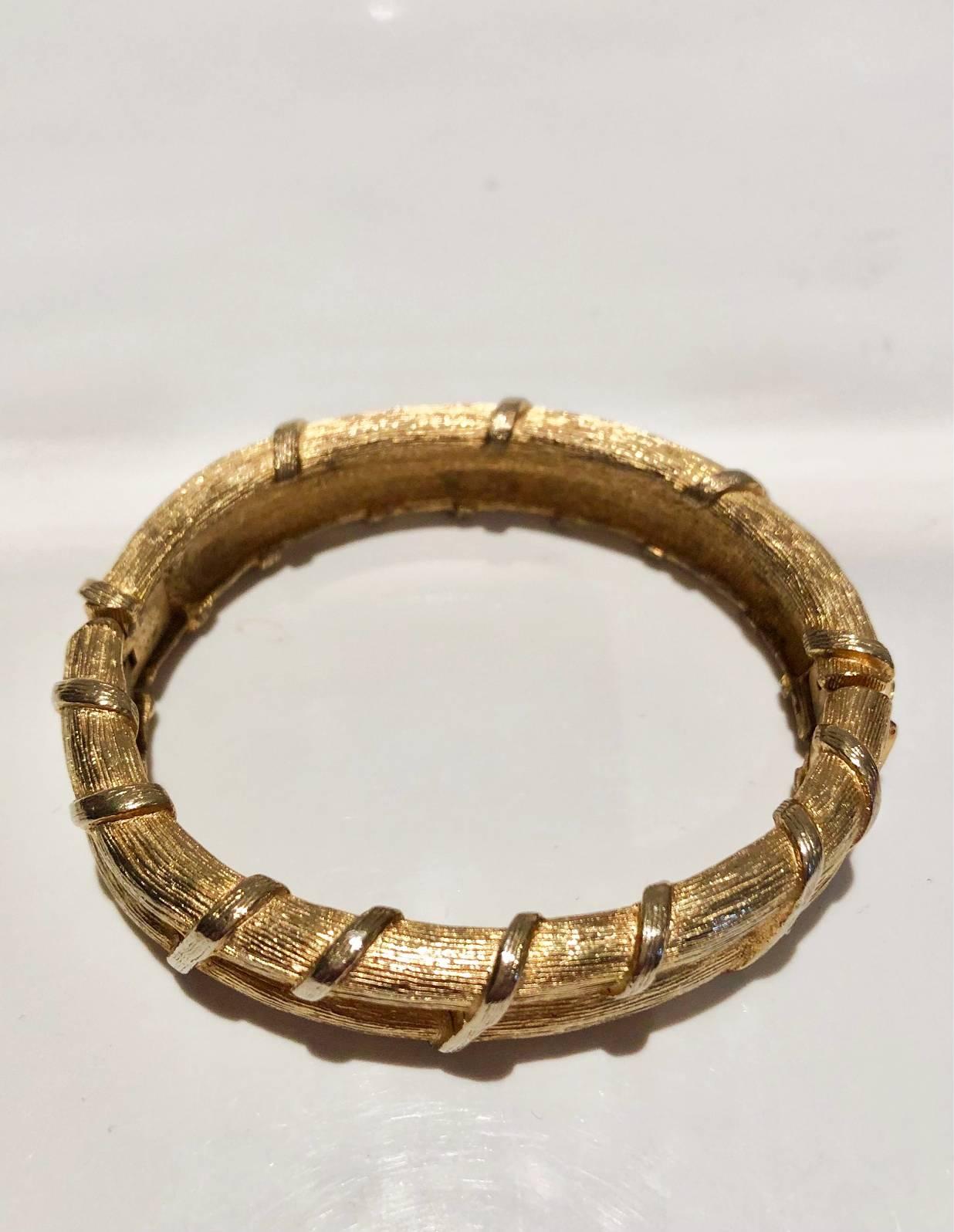 Givenchy costume jewellery slave bangle, gilt gold tone metal, clutch safe closure

Condition: vintage,1950s, wear consistent with use, very good, some light wear to gilding in places

Measurements:
- Weight: 60g
- Fits up to 6.5