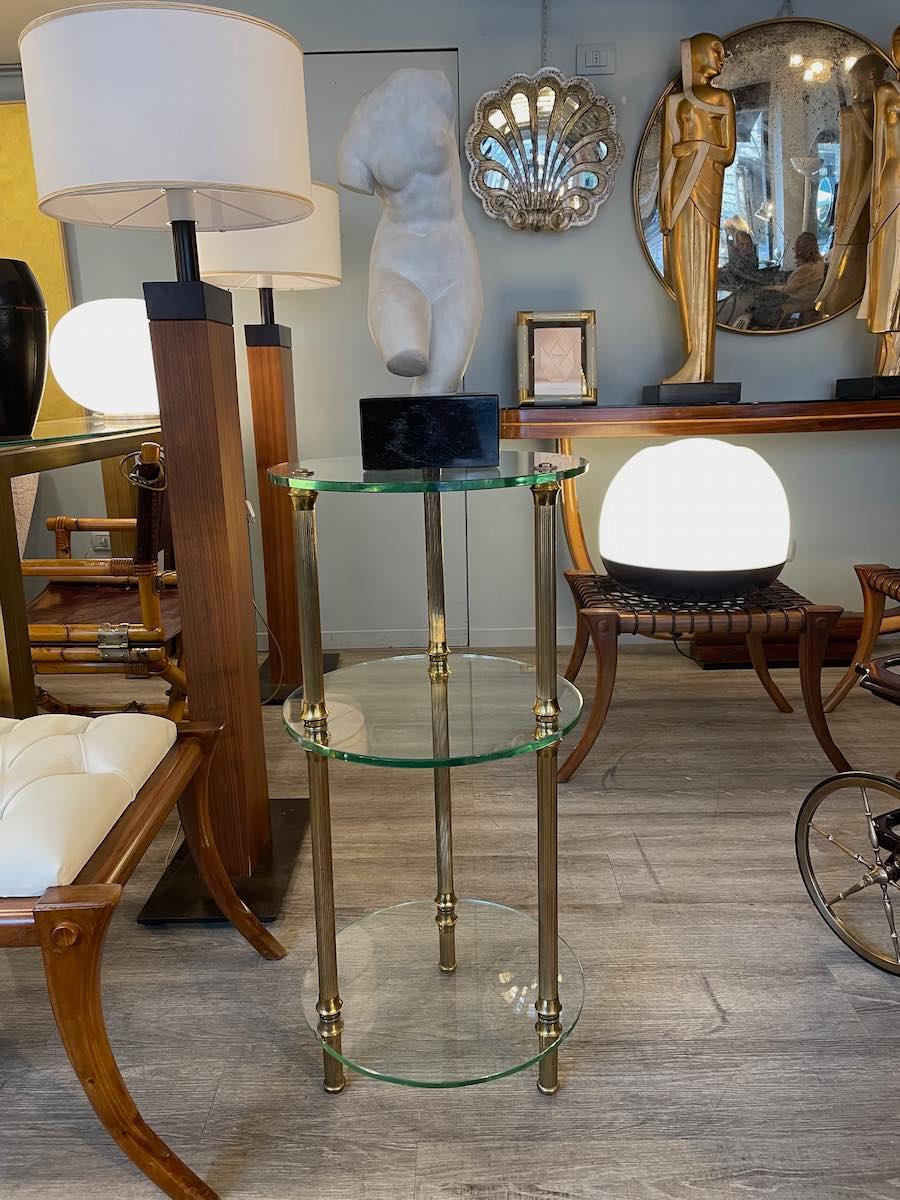 Rara mesa auxiliar de los años 50 de gran elegancia y versatilidad.
Con una estructura ligera y refinada, tiene tres estantes de cristal transparente apoyados en tres patas de latón finamente trabajadas con pies a juego.
La forma original y la