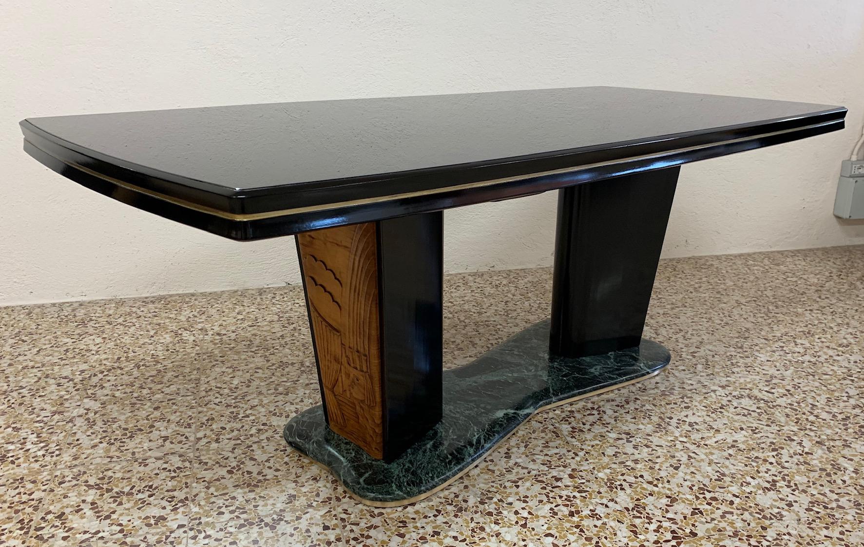 This table was made in Italy by Vittorio Dassi Lissone.
The top is black glass with the edge in black solid wood with a golden profile.
The base is formed by two large black lacquered legs with two finely carved maple panels all supported by a