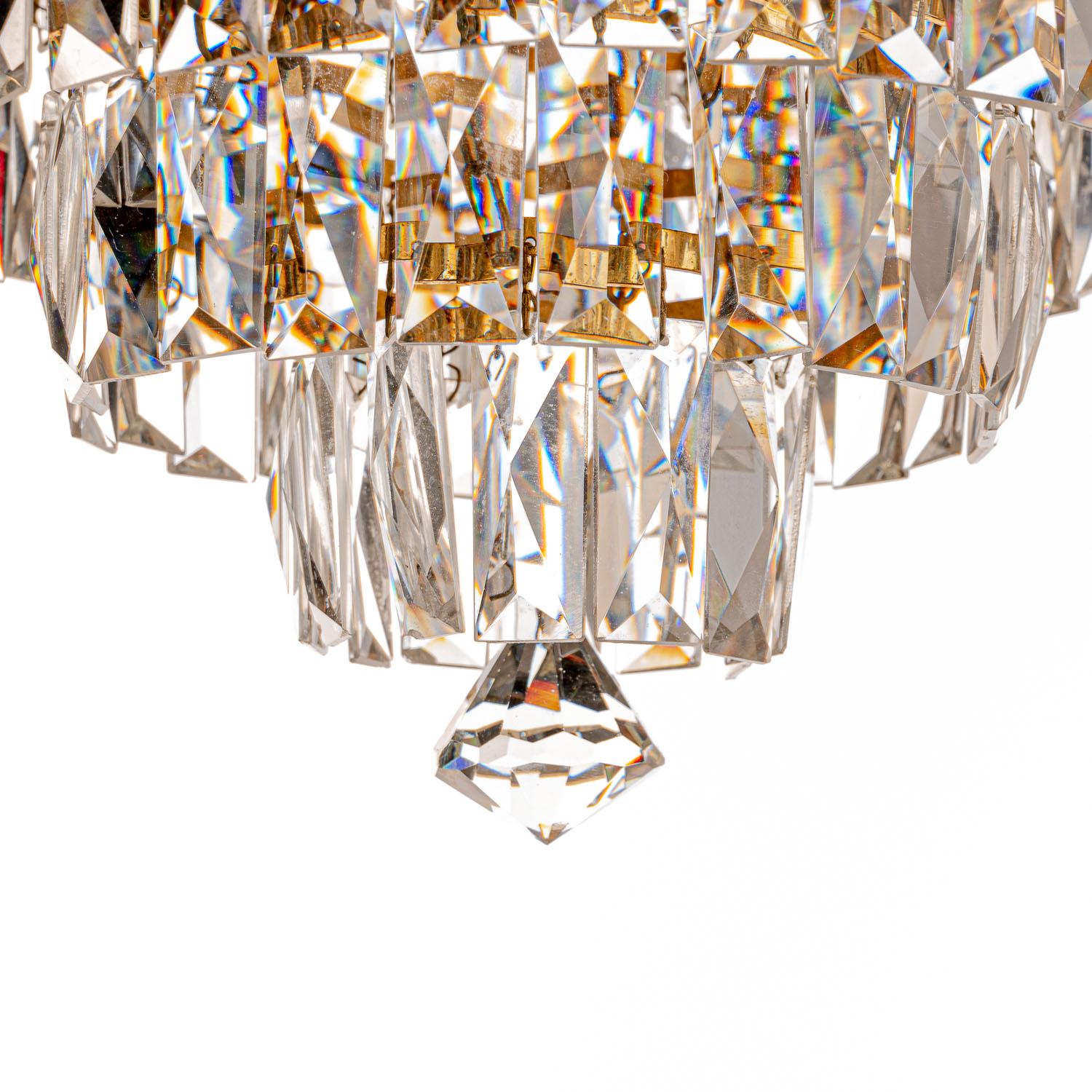 Stunning chandelier consists of five tiers of rectangle shaped glass crystals and top tier with unique cut crystals held by gold plated brass frame. Three E14 light bulbs.