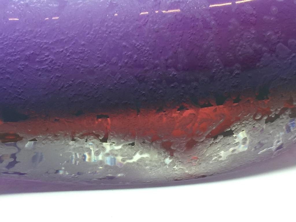 Coquillage stylisé allongé en verre sommerso gravé à l'acide, en verre violet, rouge et transparent nuancé. La sculpture a été gravée à l'acide et présente une surface texturée tactile.