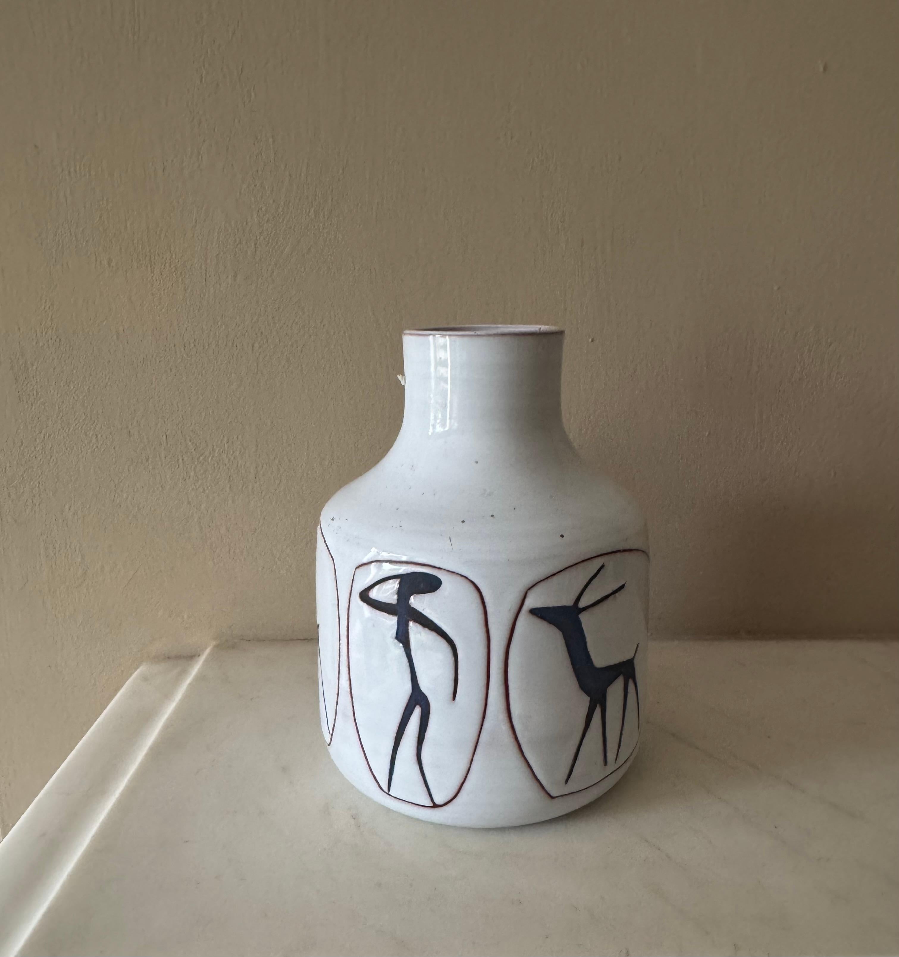 Un piccolo vaso o recipiente in ceramica smaltata bianca con figure blu a basso rilievo. Marchio Holland sul lato inferiore. 