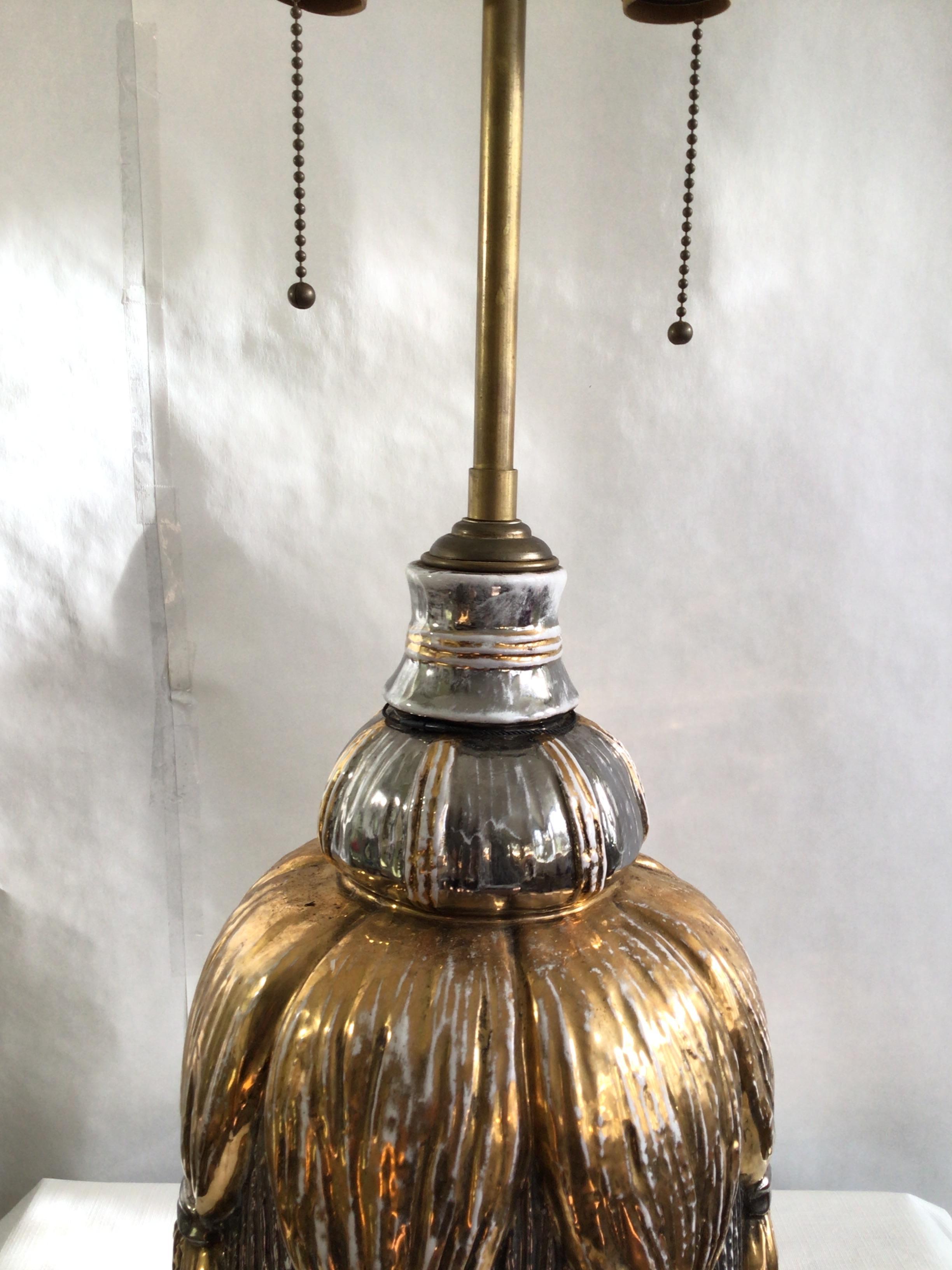 1950s Gold and Silver Painted Porcelain Tassel Table Lamp 
Needs rewiring
Height to top of washer underneath finial
Hairline cracks in glazing on underside
Minor paint loss consistent with age.