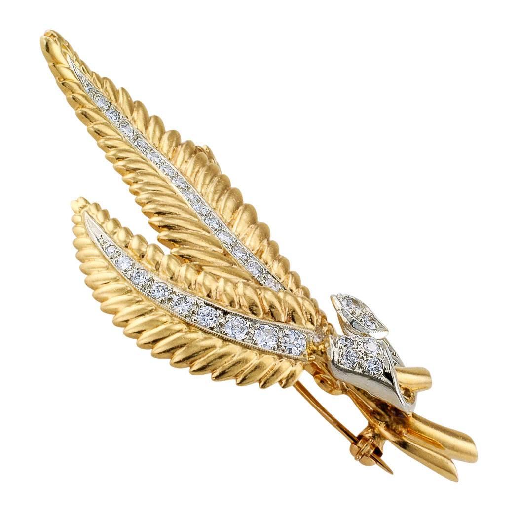 Mid-century diamond and yellow gold fern frond brooch circa 1950. Designed as a graceful trio of diamond-set fern fronds gathered at their bases by an unfurling ribbon of diamonds, the diamonds totaling approximately 1.50 carat, approximately H