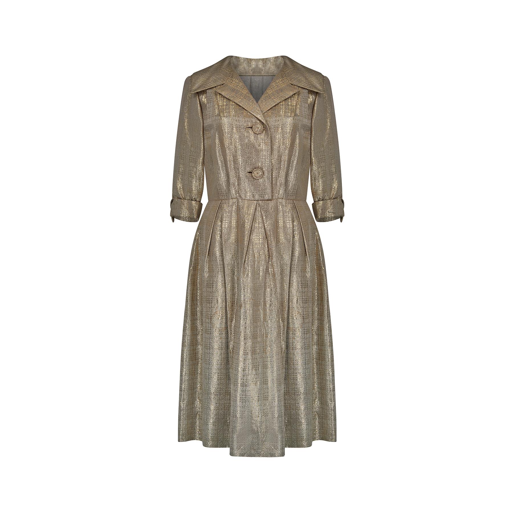 Original 1950s or early 1960s lame dress in a classic shirtwaister style with two large front fastening fabric buttons, a smart double lapel collar and a three-quarter length sleeve with turned up cuff.  The skirt has a stunning arrangement of darts