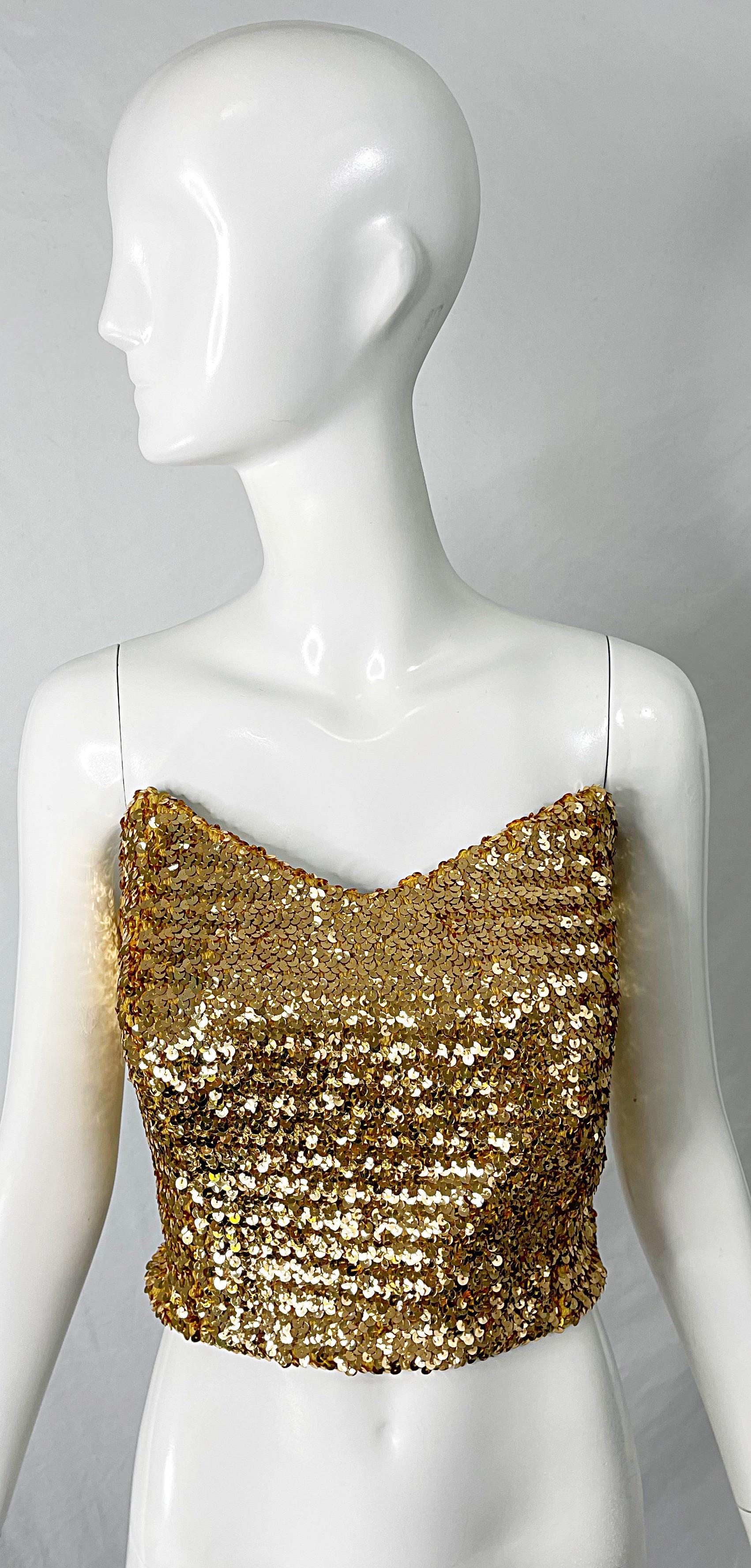 Wonderful 1950s metallic gold fully sequin strapless bustier top ! Features thousands of hand-sewn gold sequins throughout. Hidden metal zipper up the back with hook-and-eye closure. Great with jeans, a skirt, trousers or a skirt.
In great