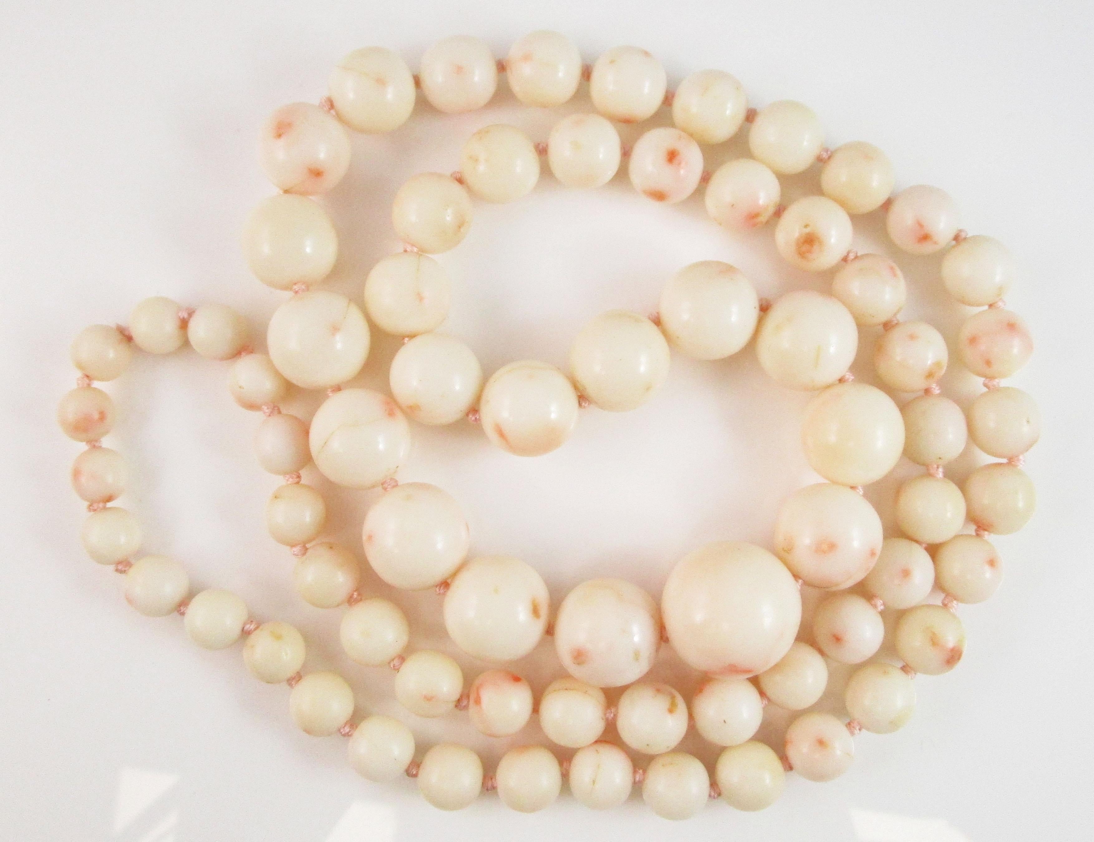This is a breathtaking white coral necklace with a dramatic graduated layout in a bold long look! The coral is a soft white color accented with splotches of stunning peach and pink. The beads are in incredible shape and are well shaped and extremely