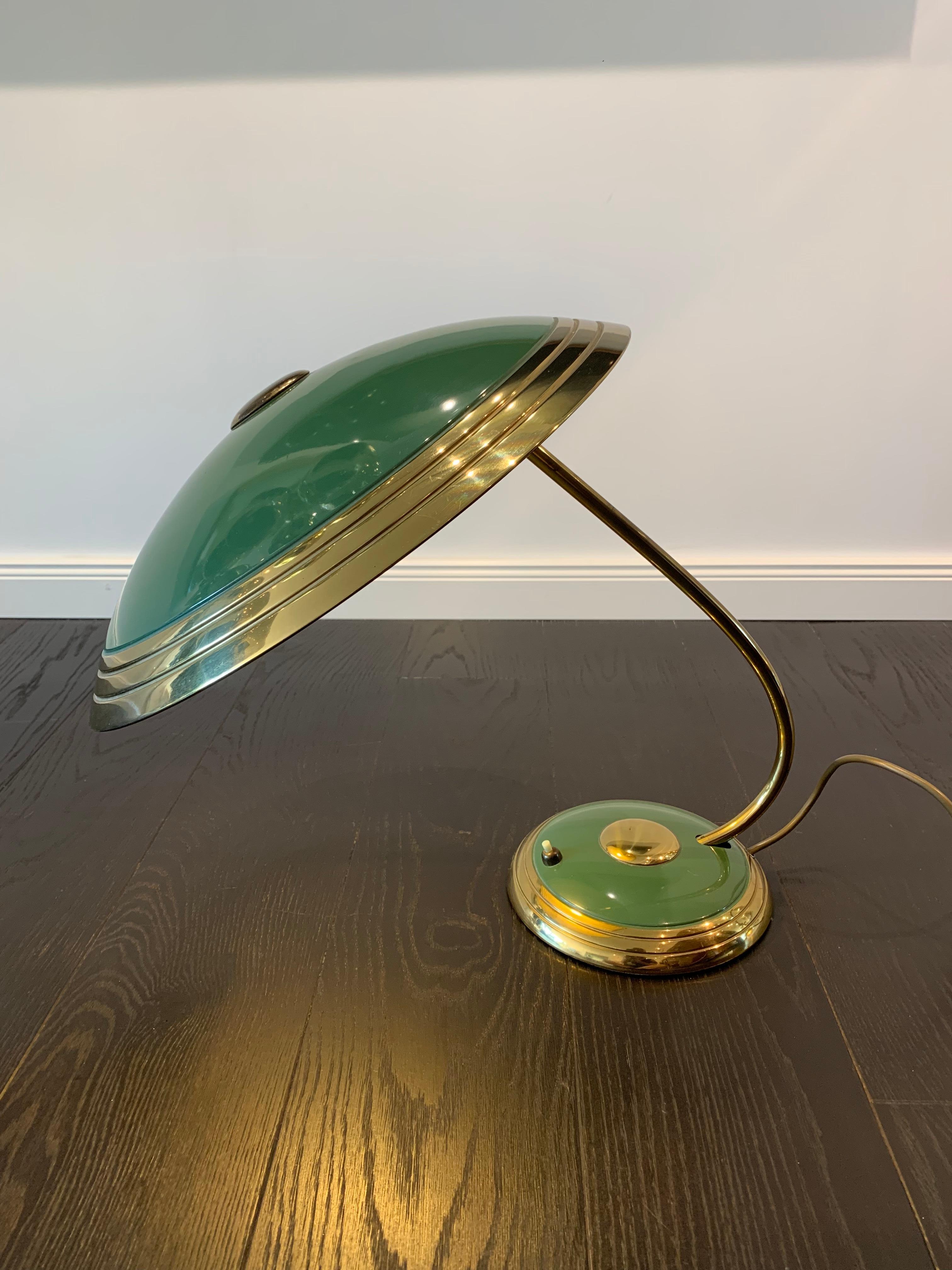 Beautiful 1950s table lamp in green and gold.
The top can be slightly tilted up and down. The light bulb is a standard E27.

Elegant office table lamp.