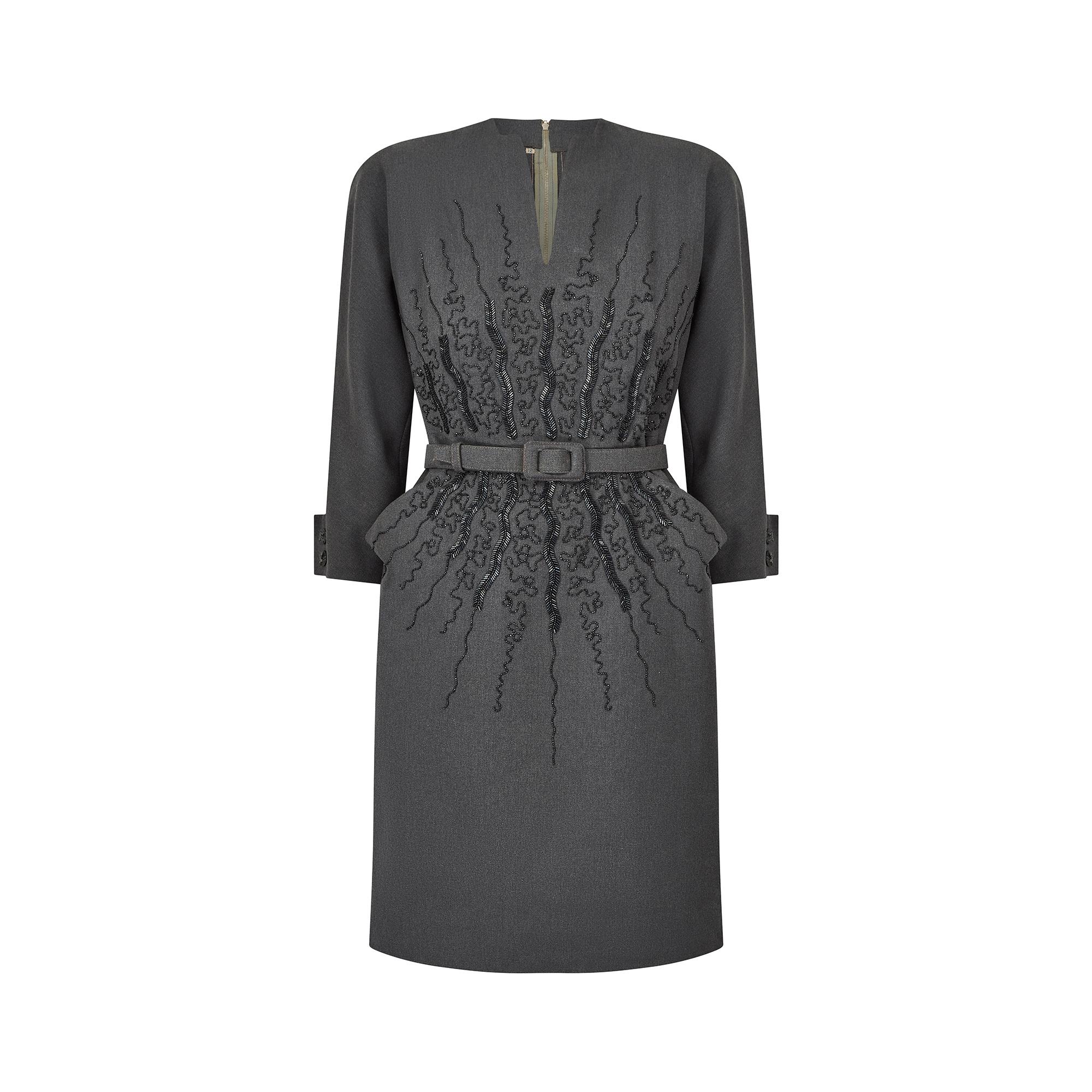 This grey wool dress dates from the very early 1950s has a lovely structured feel to it, and incredible beaded detail. The neckline is high with a small V shaped slit to the front of the bust, and the cuffs have a two button detail to each sleeve.