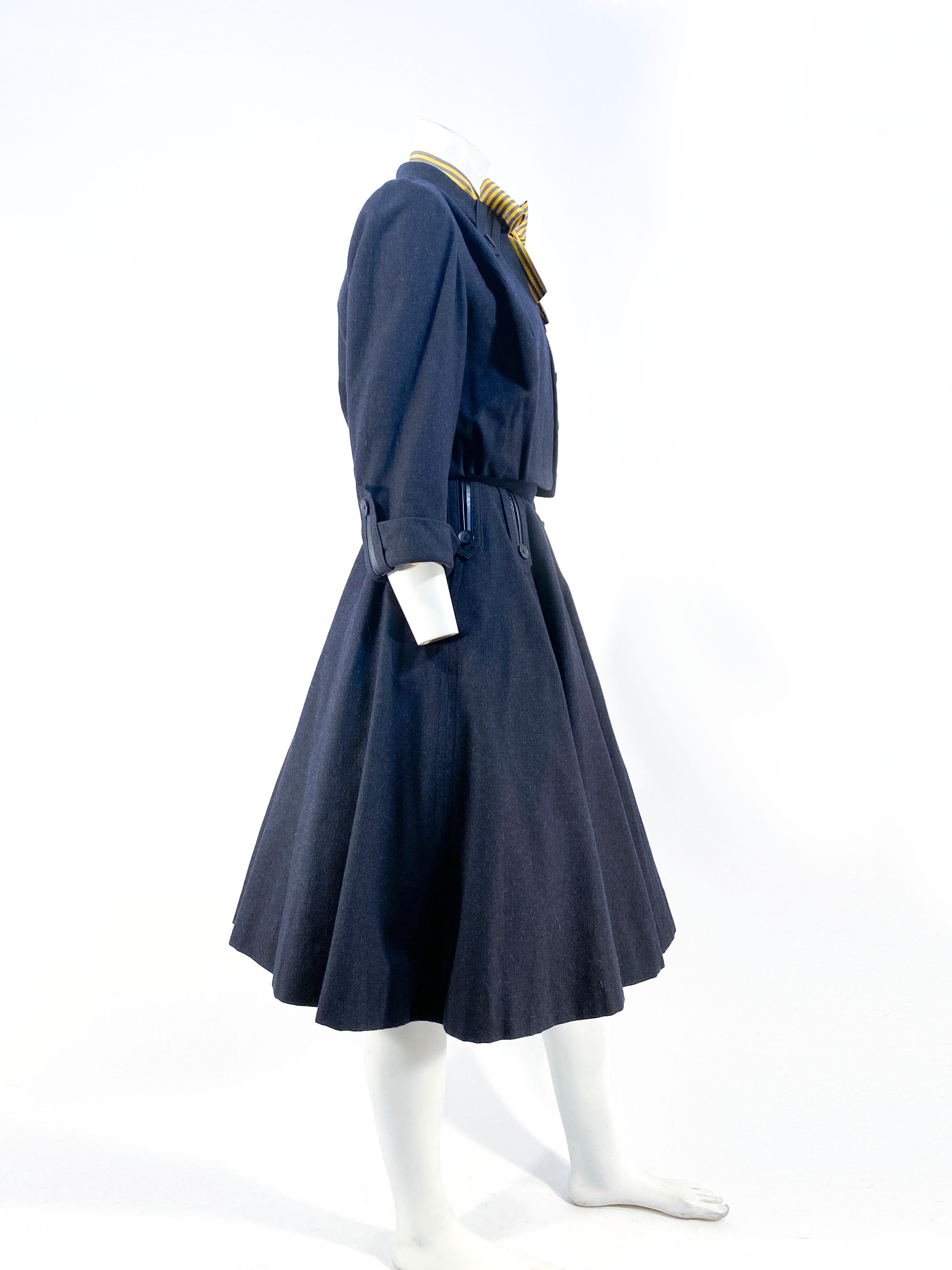 1950s grey cashmere/wool blend three-piece set including the full circle skirt with leather and wool tapers with button accents. The copped jacket has three-quarter length cuffed sleeves with matching tapper accents along the cuffs and collar. The