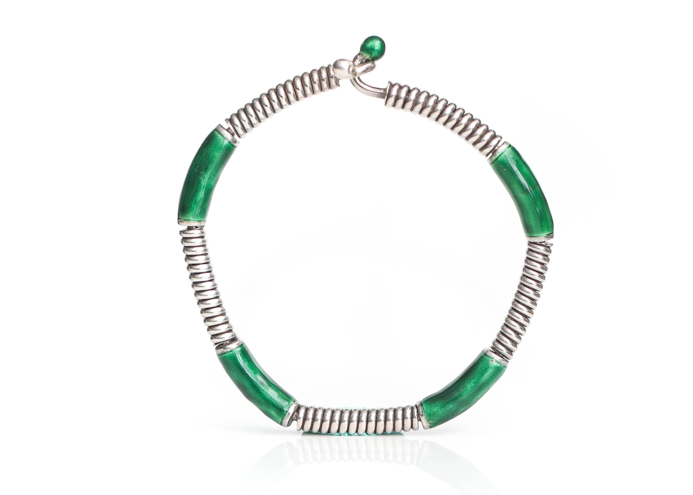 Gucci Sterling Silver, Green Enamel Bangle Cuff Bracelet

Features 4 Sterling Silver Wire Coil segments alternating with 4 Green Glossy Enamel segments. The bracelet ends with one Sterling Silver sphere and one Green Enamel sphere. The ends of the