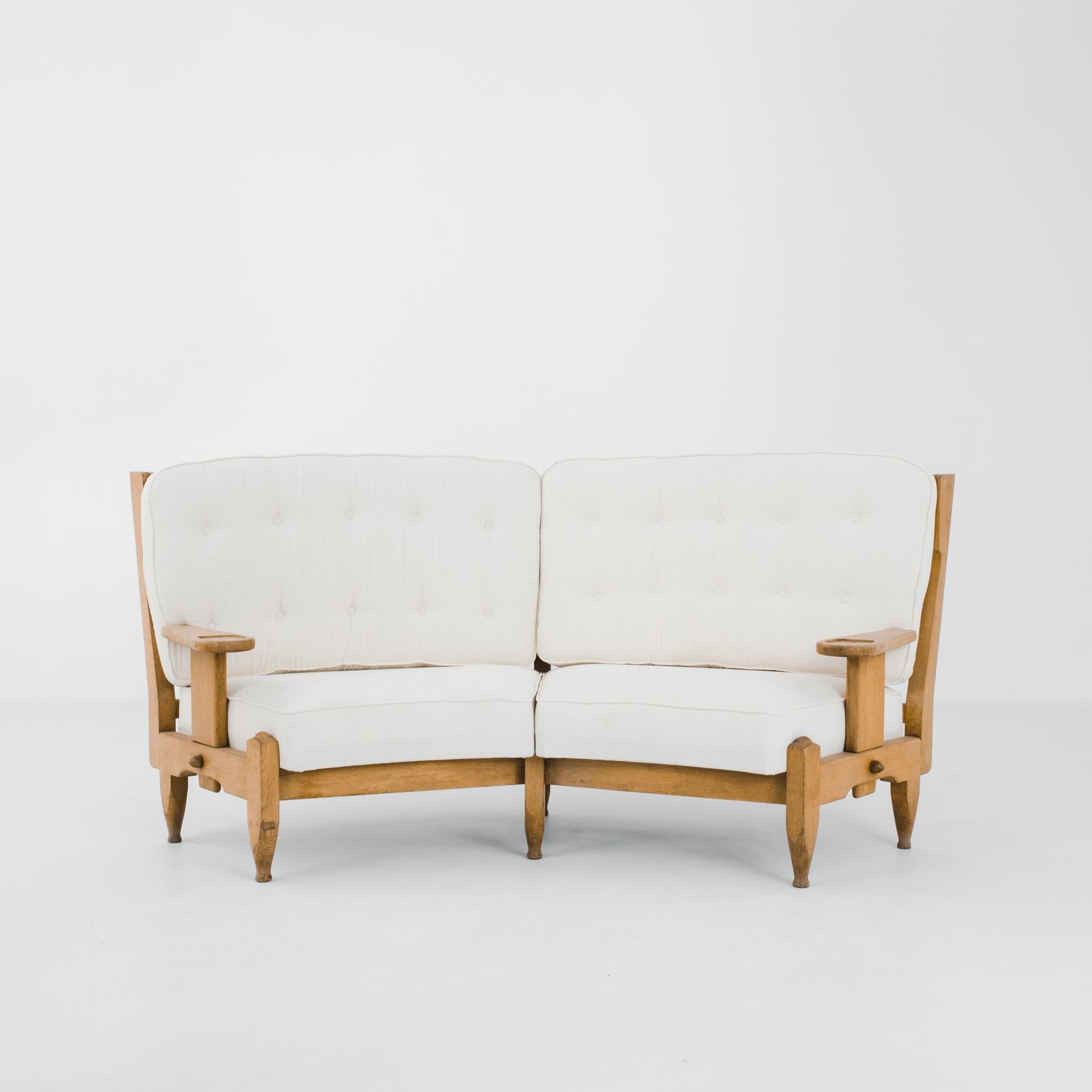 The graceful curve of this oak sofa by French designers Guillerme et Chambron makes an effortlessly elegant impression. Warm oak with a natural finish is fashioned into a light frame; the repeated oval of the back-slats creates an eye-catching