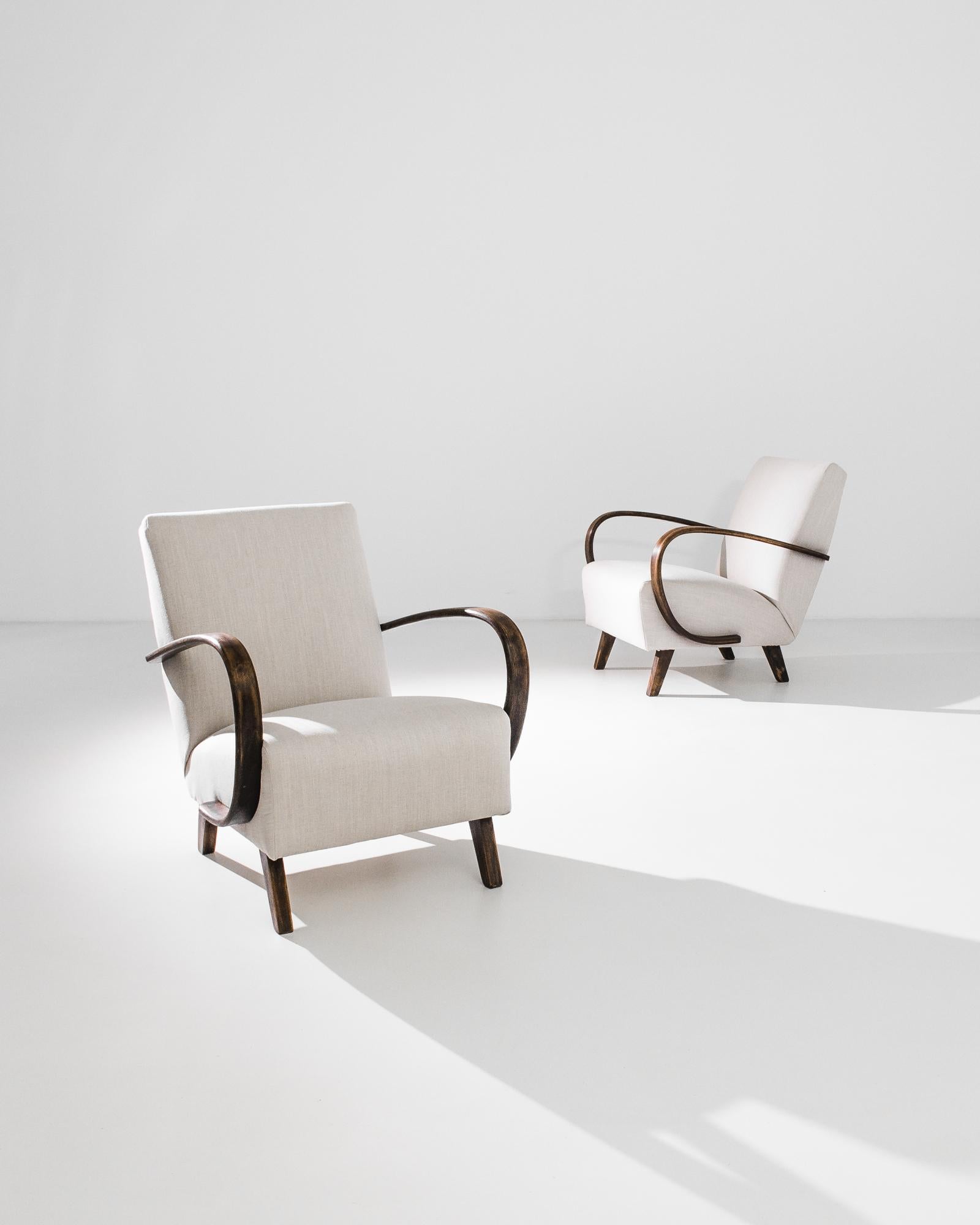 A pair of armchairs by Czech furniture designer J. Halabala. Made in the 1950s, the design was produced in Central European furniture factories throughout the mid-20th Century. The eye-catching silhouette and comfortable shape has had an enduring