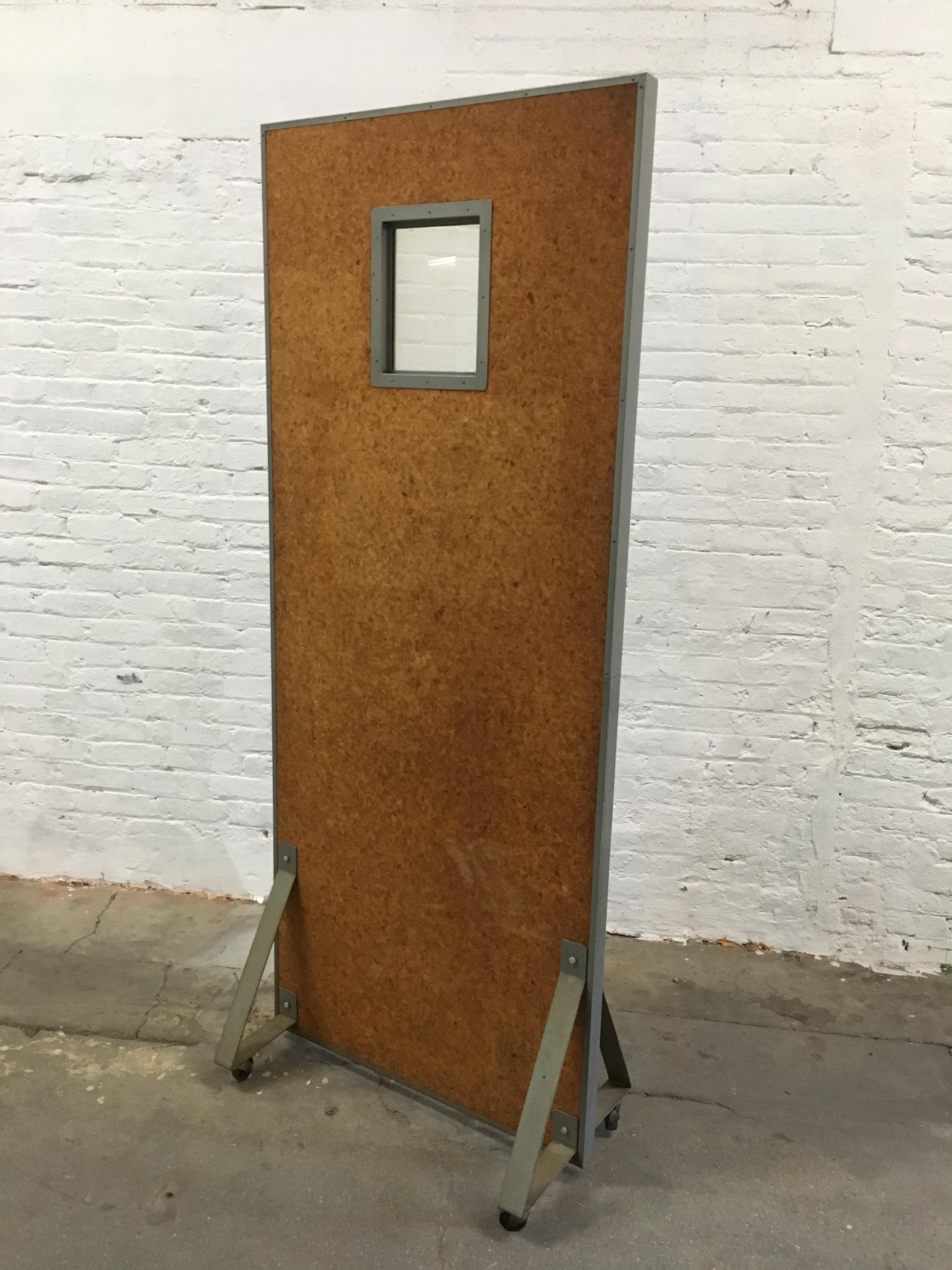 Massive cork faced and steel medical X-ray room divider. Old school medical office X-ray partition signed with metal plaque, Halsey, Brooklyn, New York. Gray powder coated frame with a cork veneer on both sides with hard rubber wheels, circa