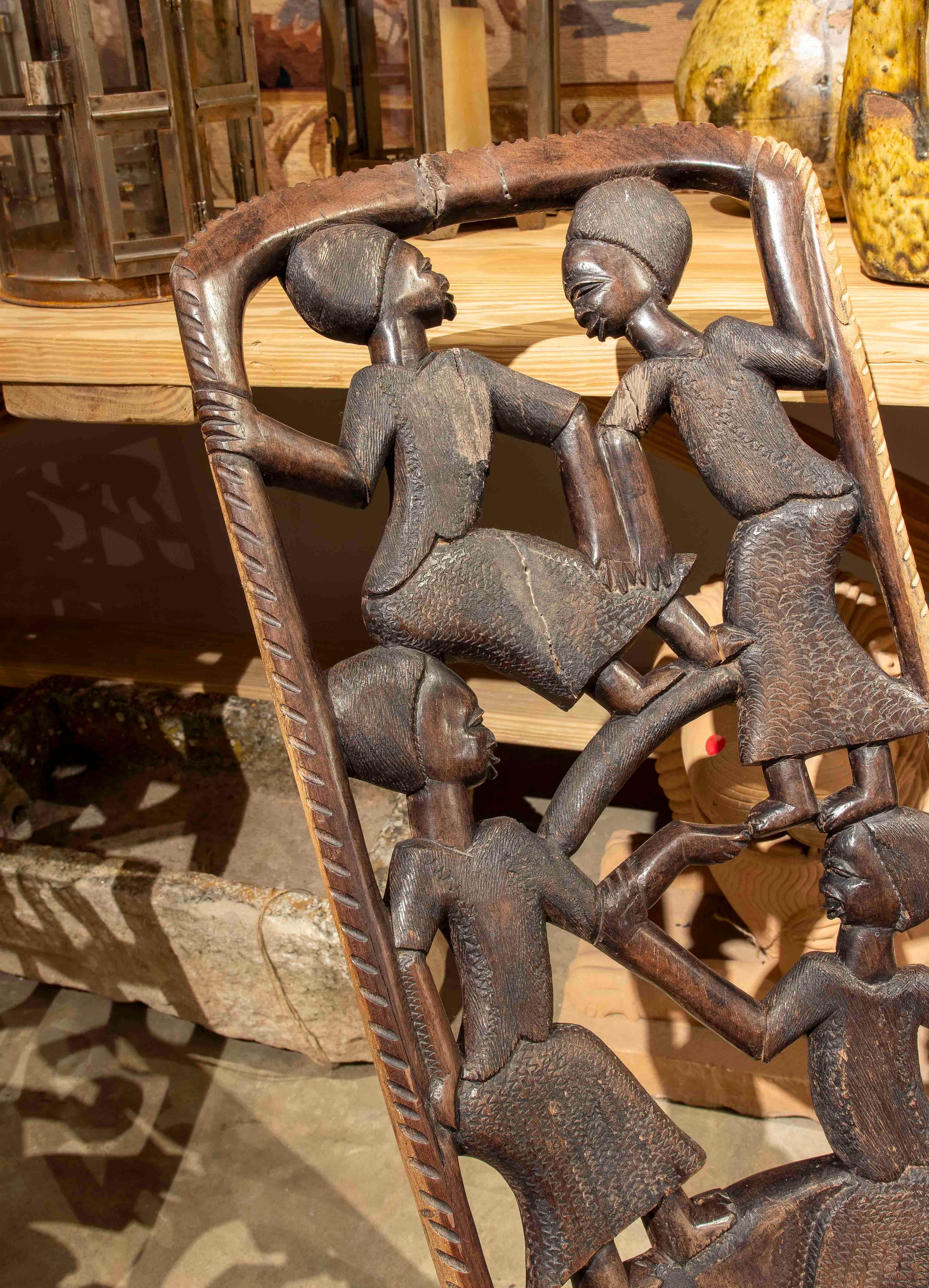 Legno Sedia etnica degli anni '50 intagliata a mano con scene di comunità e tradizione. in vendita