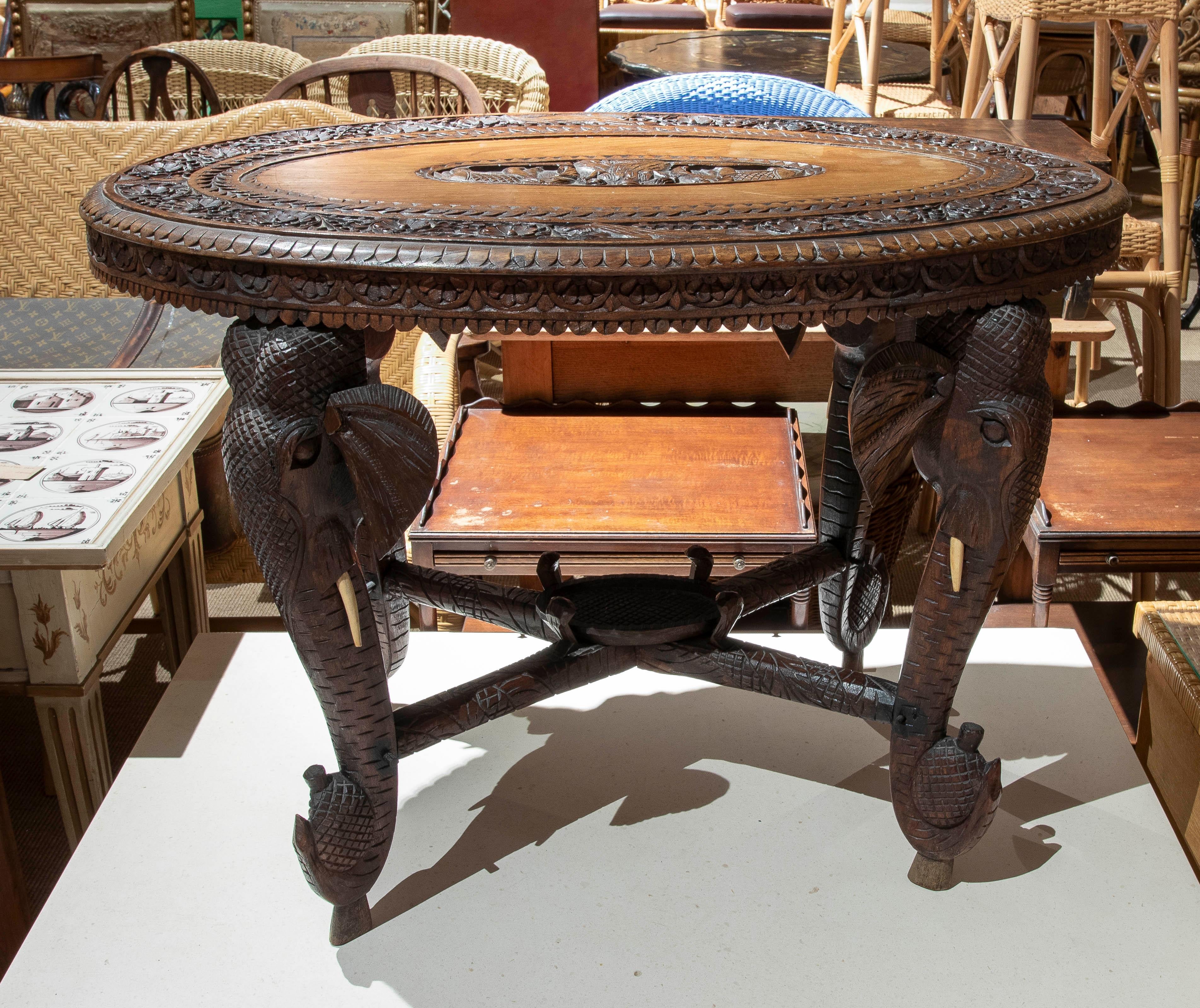 Mesa Indu de madera tallada a mano de los años 50 con patas de elefante y motivos florales Indio en venta