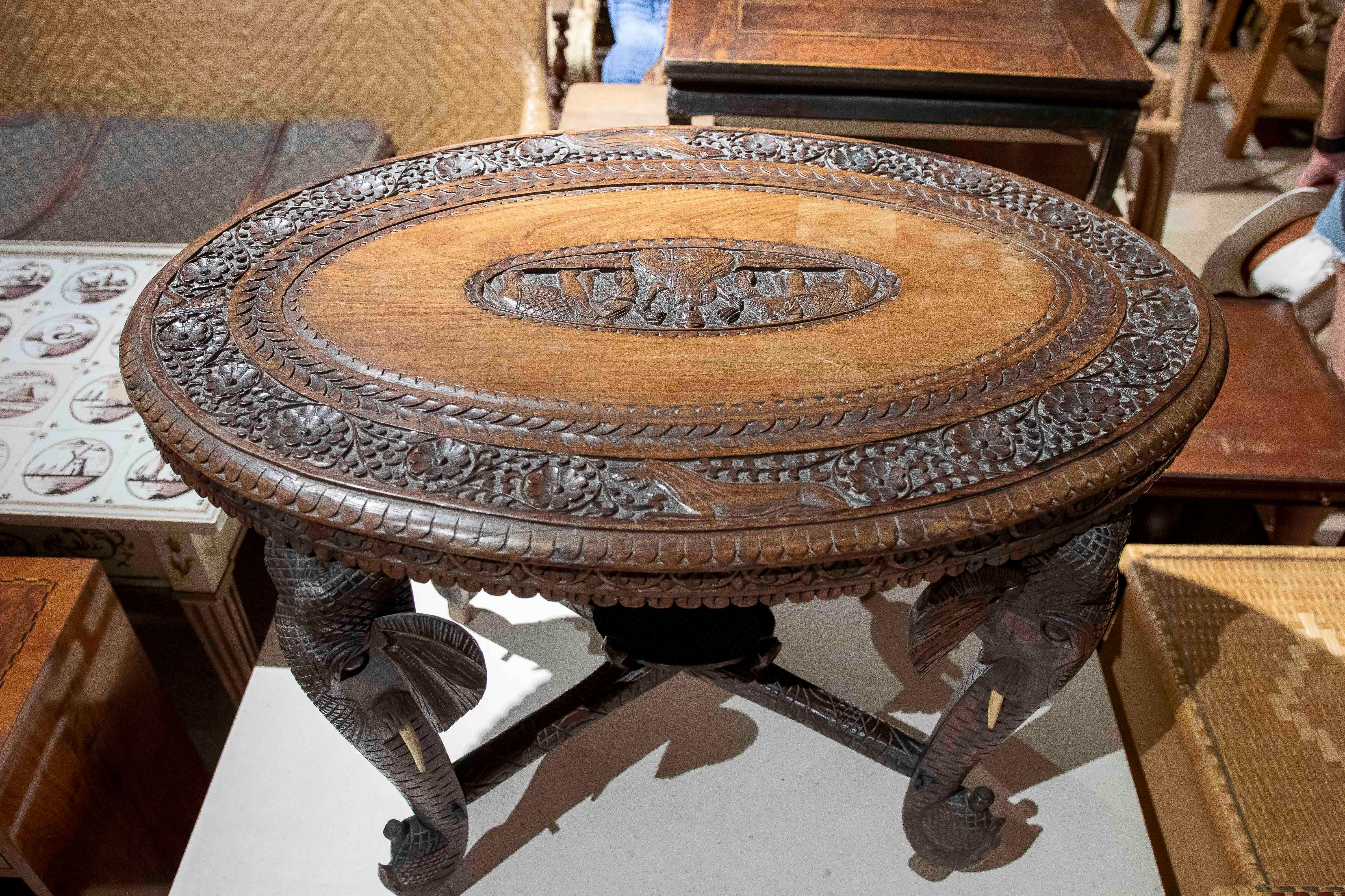 Mesa Indu de madera tallada a mano de los años 50 con patas de elefante y motivos florales en Bueno estado para la venta en Marbella, ES