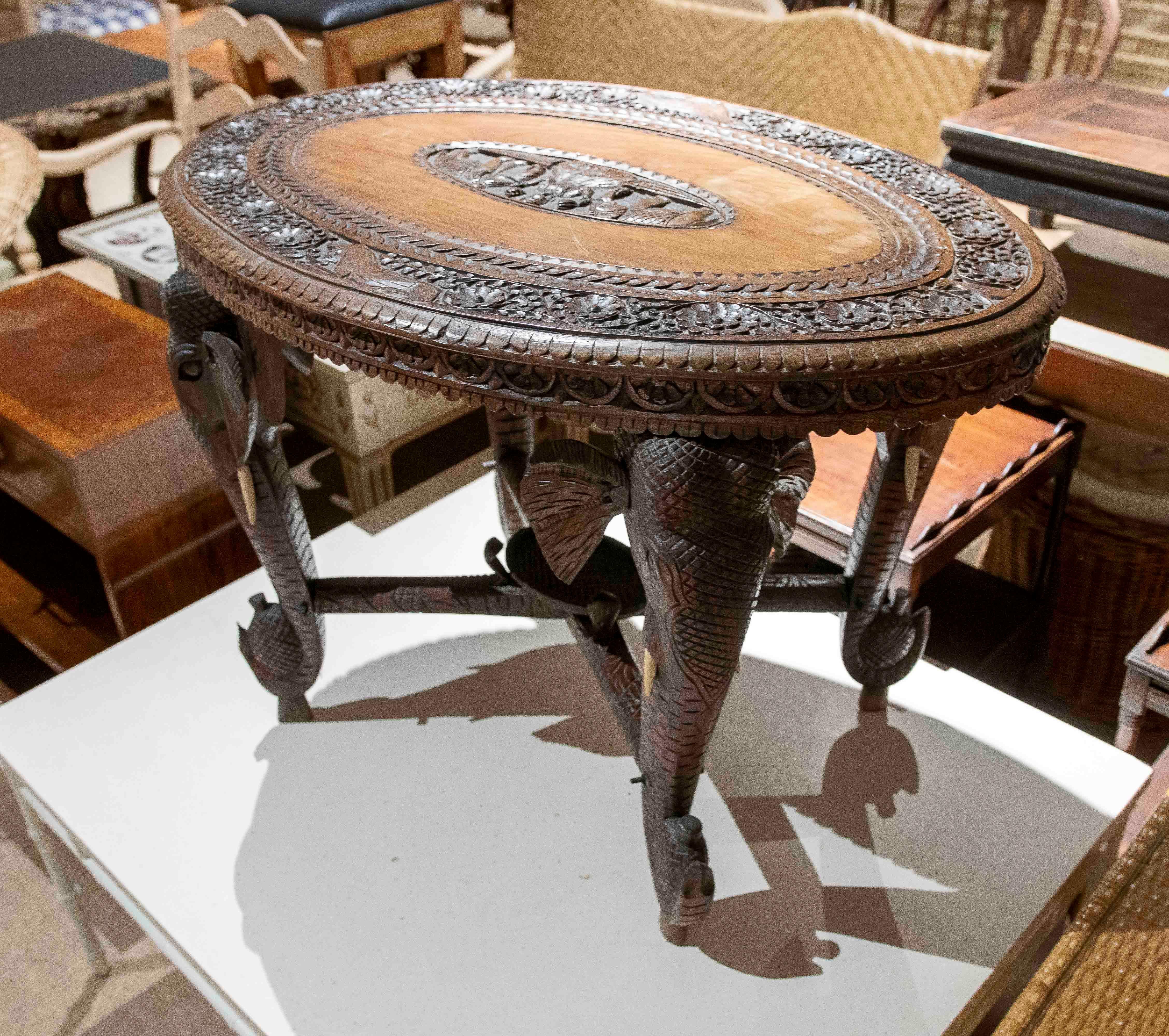 Mesa Indu de madera tallada a mano de los años 50 con patas de elefante y motivos florales en venta 1