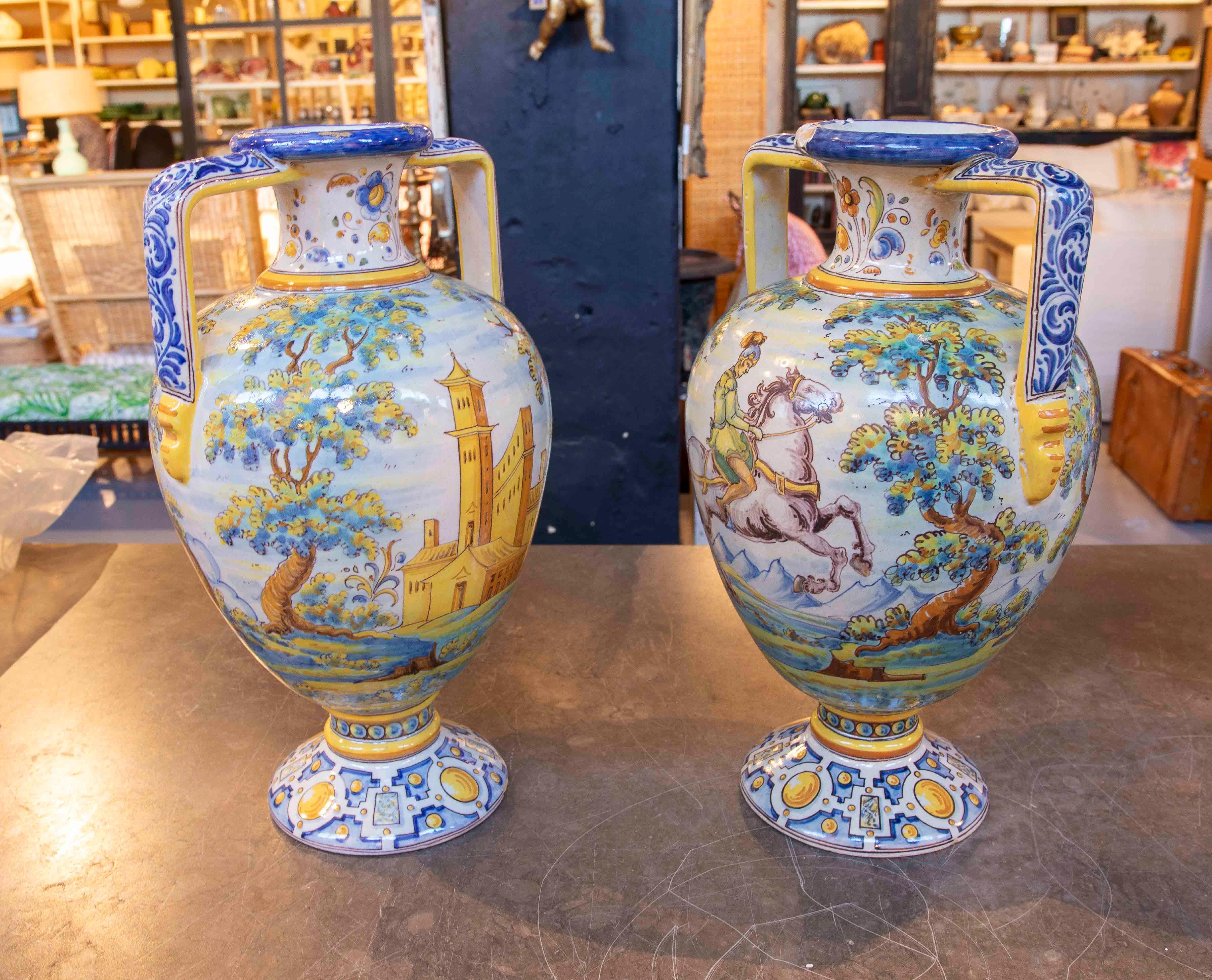 Superbe ensemble de deux vases fabriqués à la main par Juan Ruiz de Luna à Talavera, en Espagne, signés et numérotés. Ces pièces uniques en céramique émaillée présentent des scènes peintes à la main dans des couleurs vives : l'une représente une