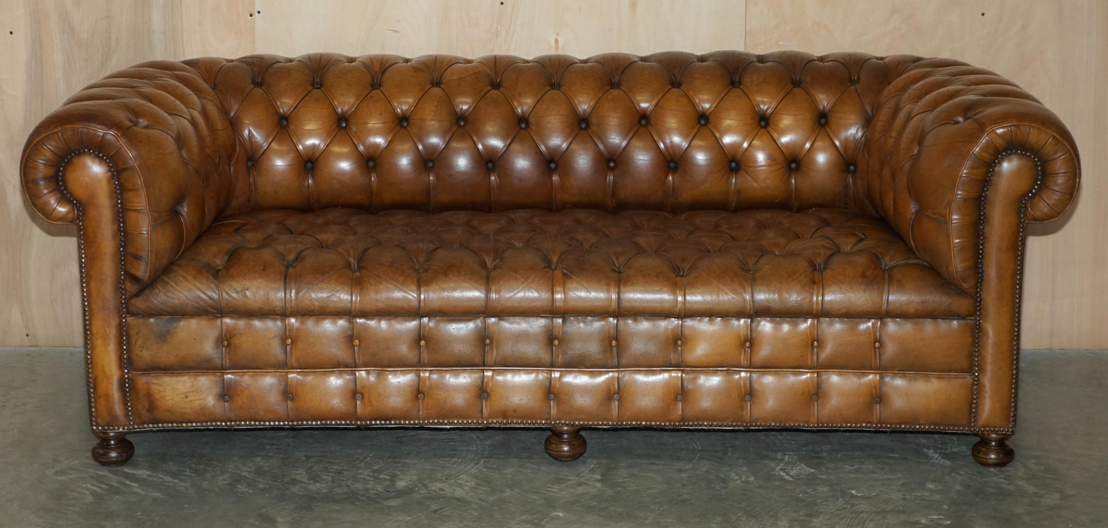 Nous avons le plaisir de proposer à la vente ce canapé club Chesterfield original des années 1950 en cuir brun cigare, légèrement restauré, avec une base entièrement boutonnée et des pieds tournés en noyer massif.

Il s'agit d'une trouvaille