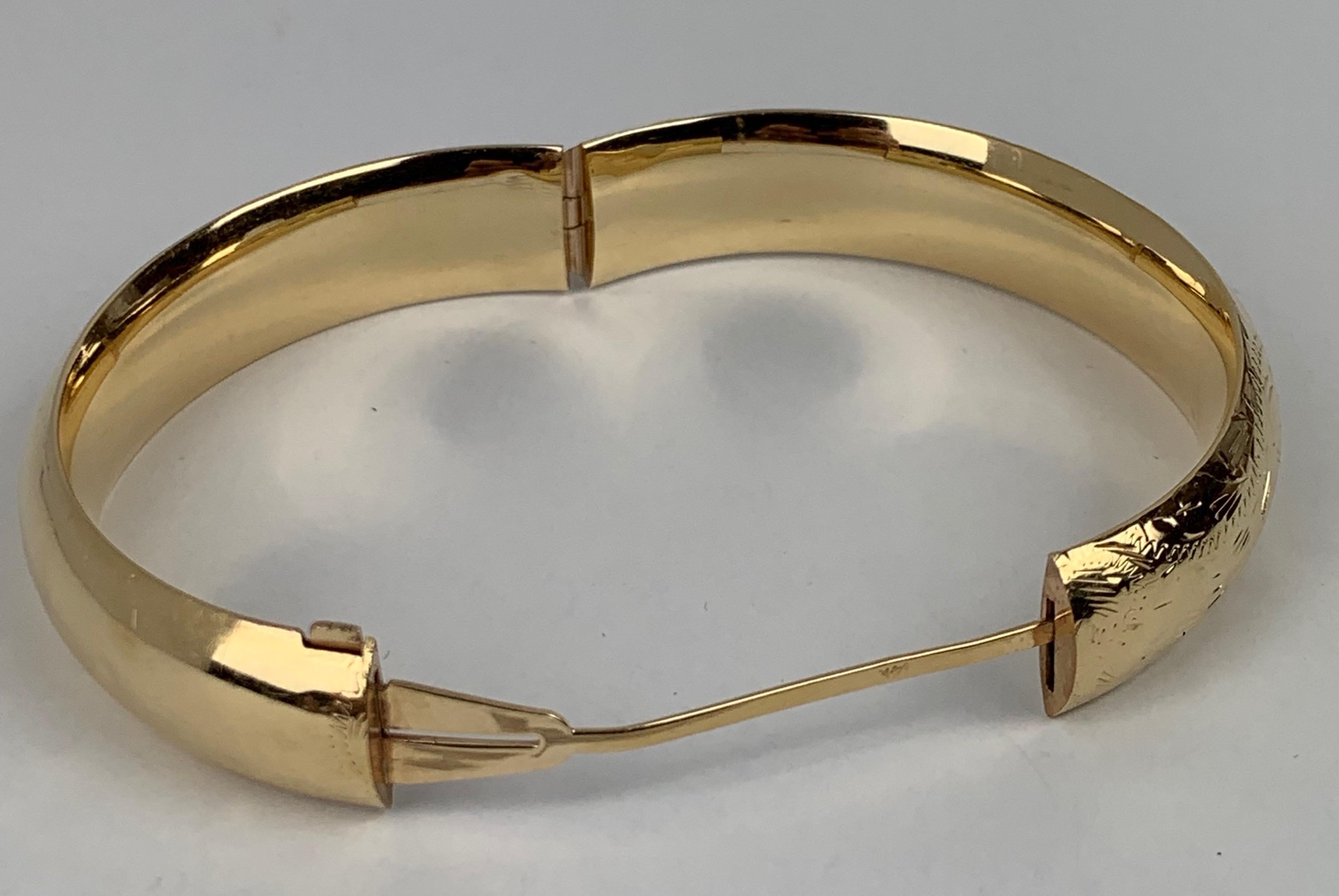 1950's 14k yellow gold bangle bracelet, slightly domed and hand engraved.  The area for monogramming has been left untouched.  There are several tiny dimples on the underside of the bracelet.  The catch is very tight.

20 grams
inside diameter 2