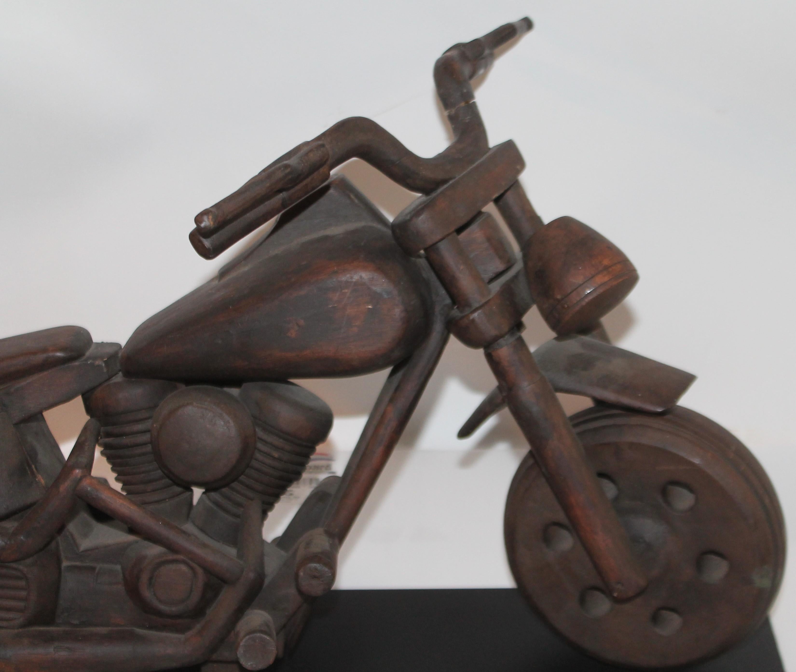 This very cool motor cycle is a hand carved Harley Davidson from the 1960s. This is a very unusual very unique model. Rarely see is the motor cycle in a hand carved form on a custom iron mount.