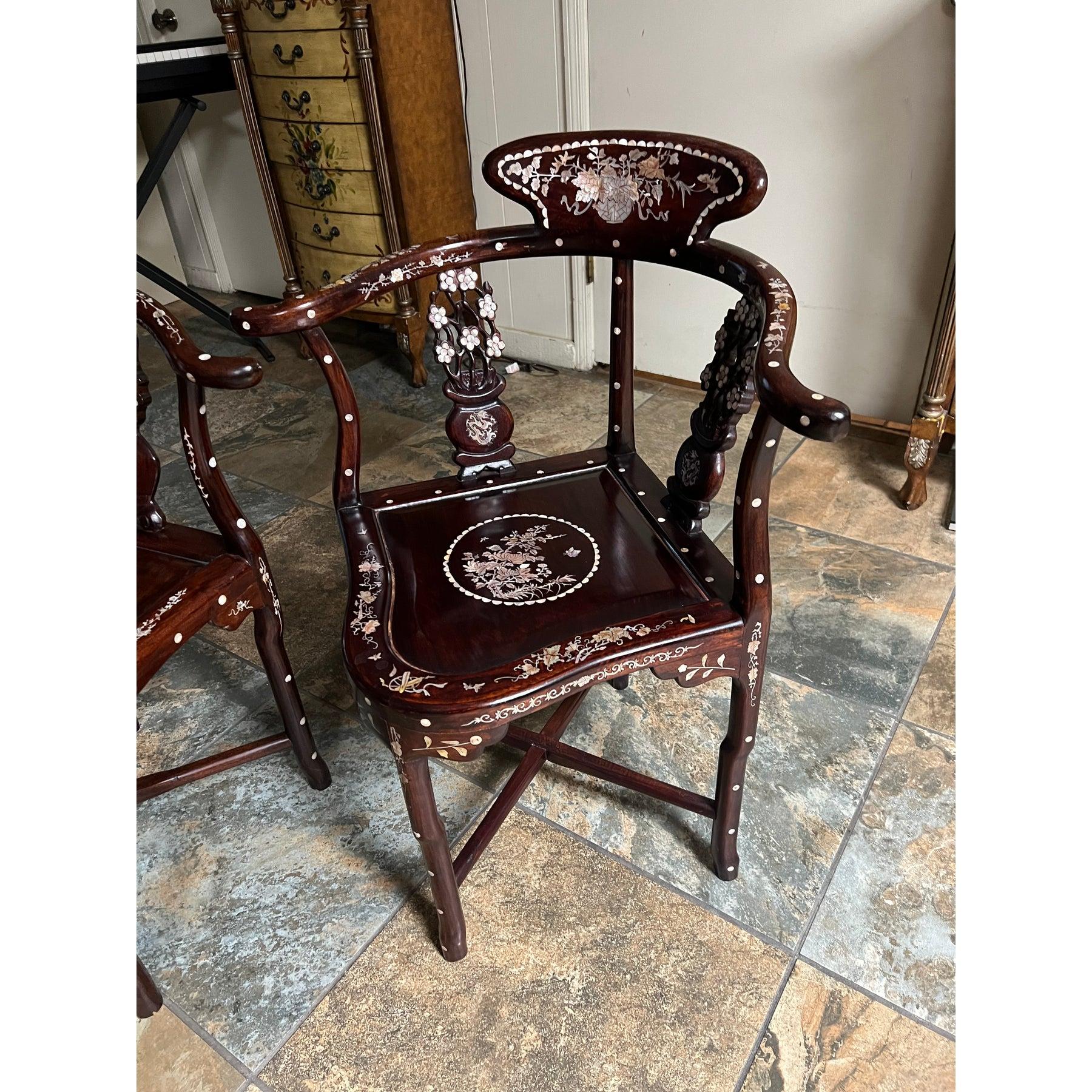 Superbe chaise d'angle vintage en bois de rose chinois sculpté à la main, ornée de motifs complexes en nacre.
de perles représentant des motifs floraux et des oiseaux. Avec des accoudoirs incurvés et de riches
En finition bois de rose, ces chaises