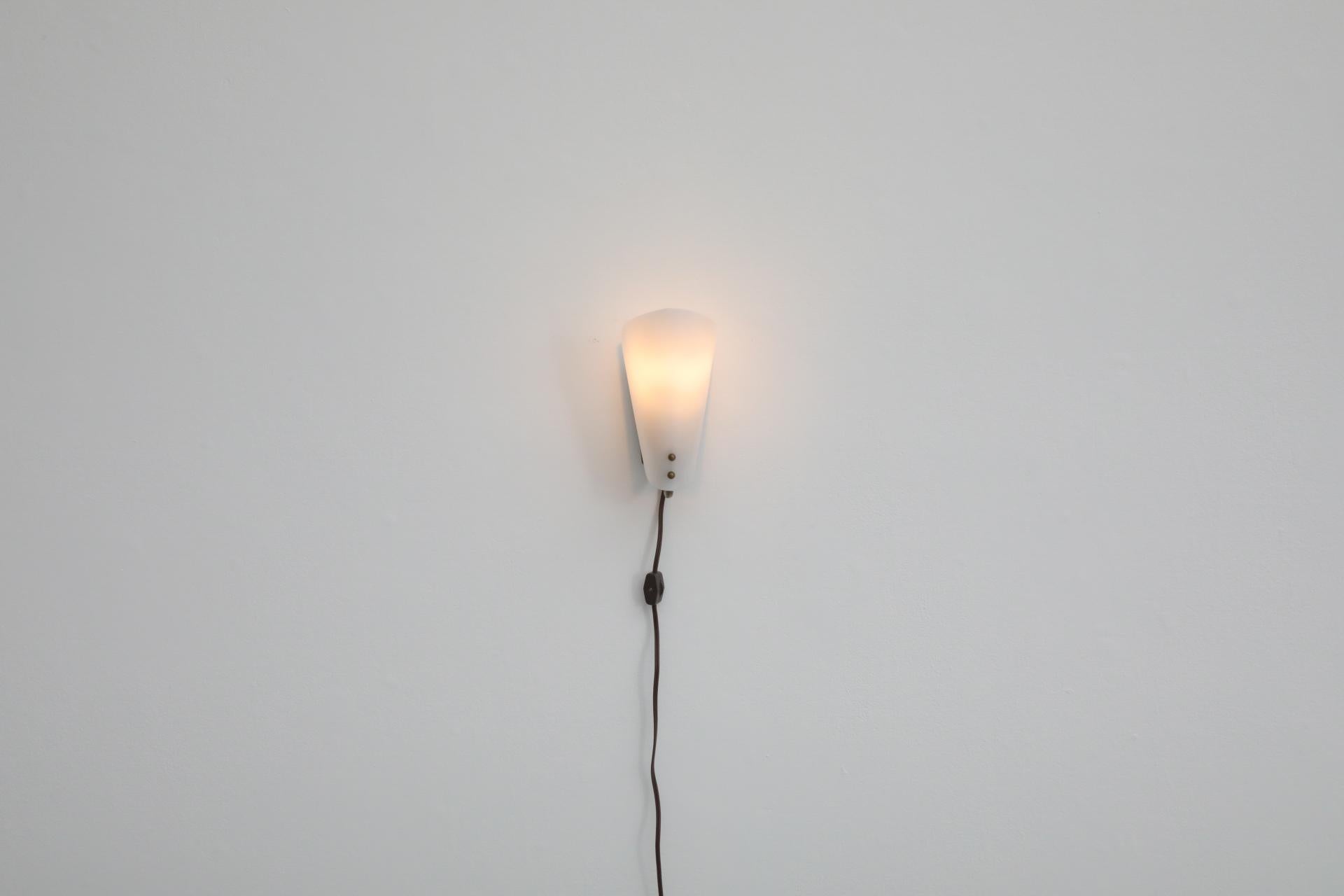 1950's Hanns Hoffmann-Lederer style plexi wall sconce with brass base and accents. In original condition with visible wear, including light scratches and patina. Switch on cord. Wear is consistent with its age and use.