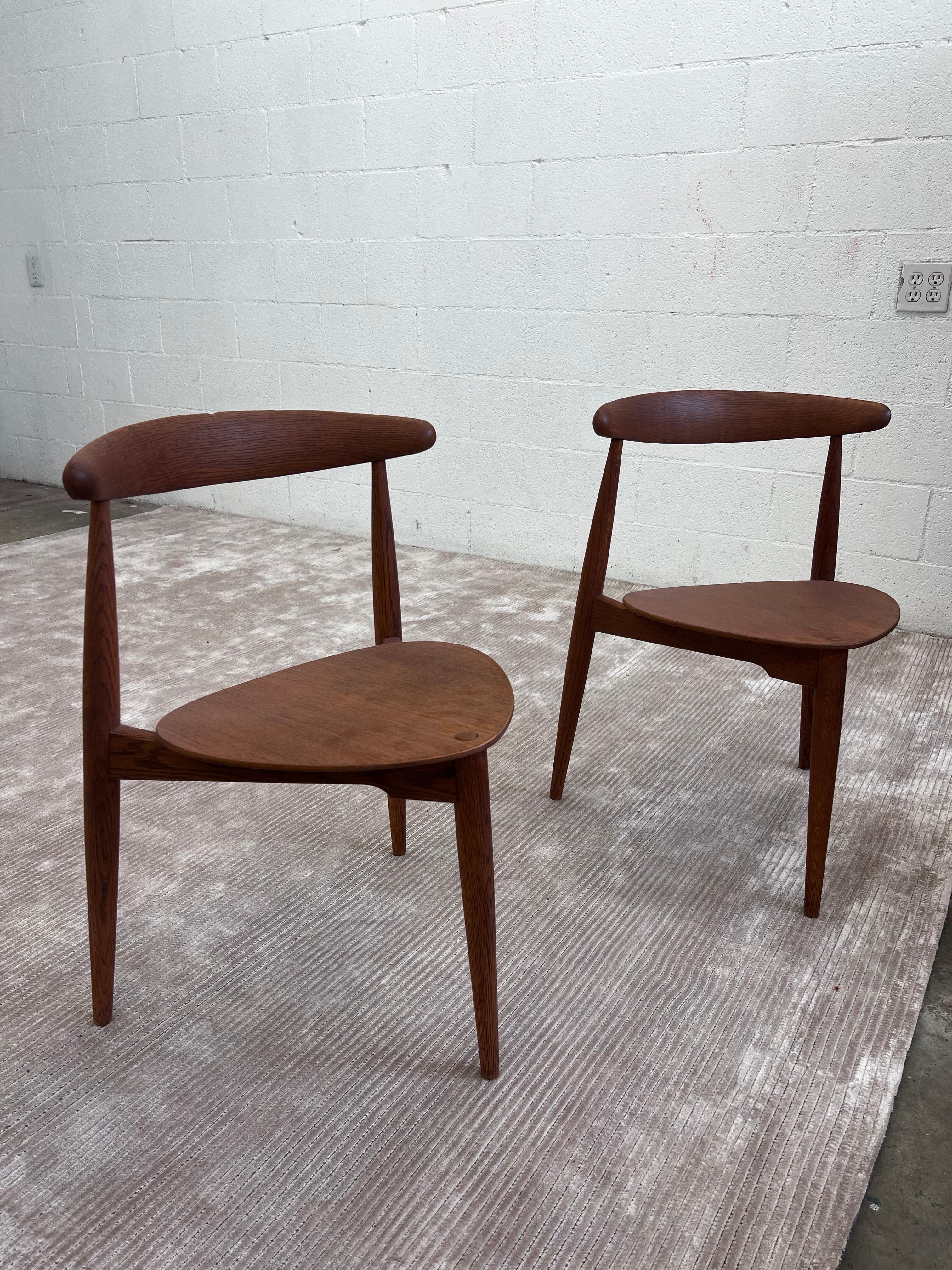 Two Hans Wegner Heart Dining chairs. These particular examples were manufactured in the 1950s in Denmark, however interesting enough one chair was manufactured by Fritz Hansen and the other was manufactured by illums bolighus. Both licensed