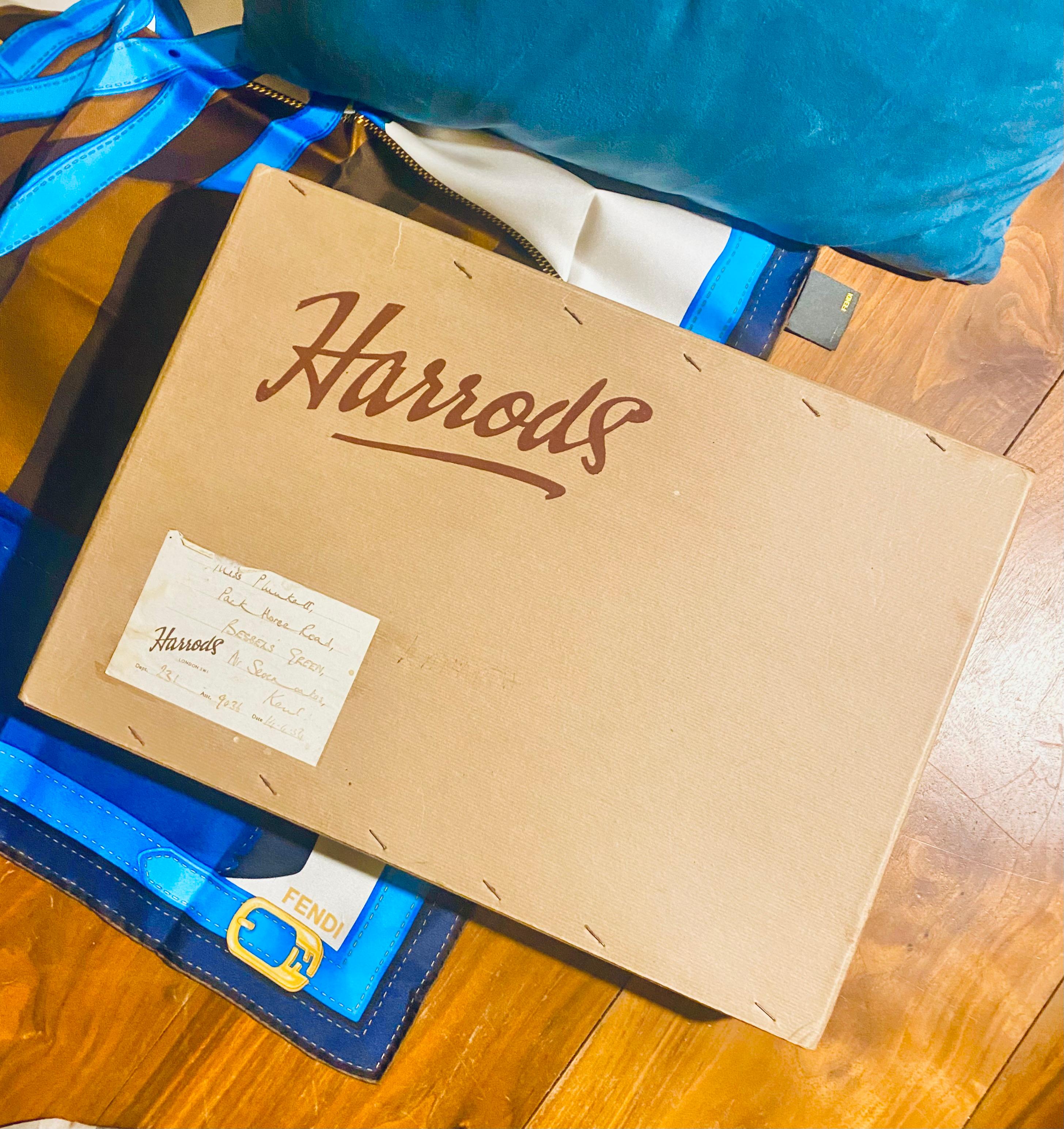 This vintage Harrods cardboard box boasts the iconic 1950s logo in a deep burgundy hue. The original address label adds a touch of nostalgia and luxury to this elegant piece, perfect for those who appreciate the finer things. Own a piece of history