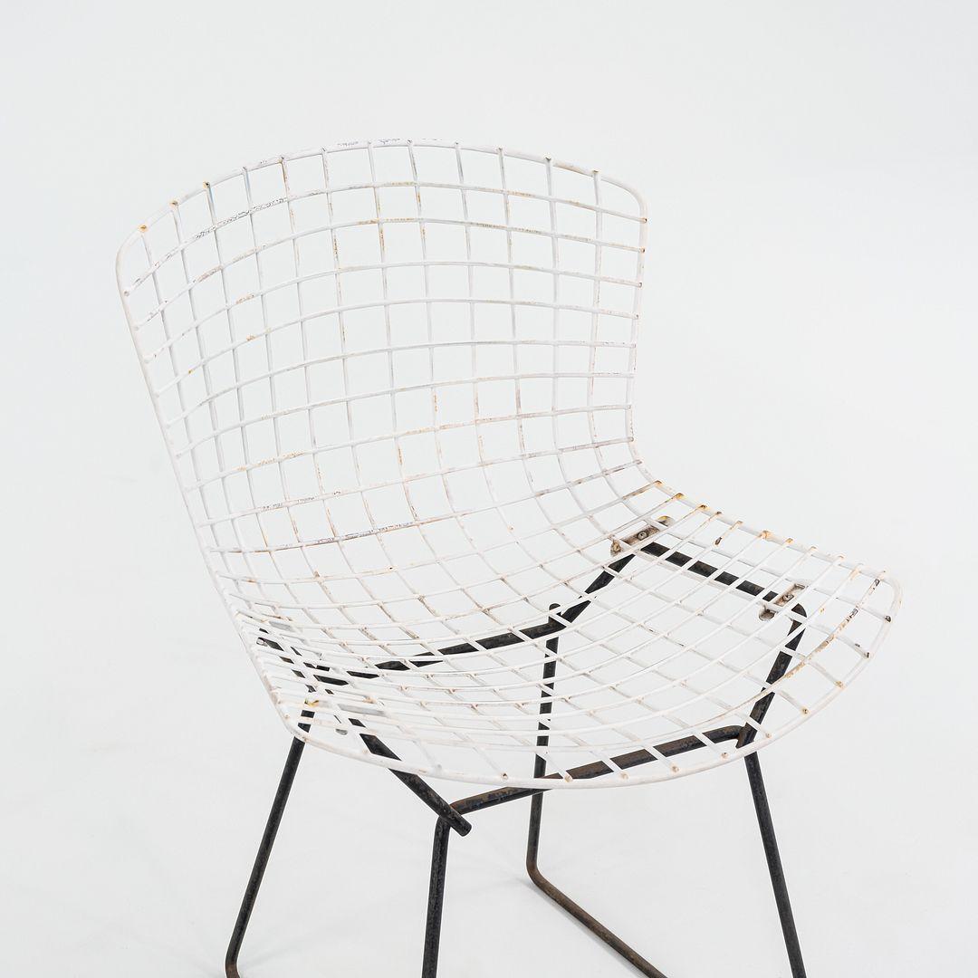 This is a Bertoia Two Tone side chair, originally designed by Harry Bertoia in 1952. This particular example was produced by Knoll in the USA in the 1950s. The design is comprised of welded steel rods, the seat being white with a black base. 

The