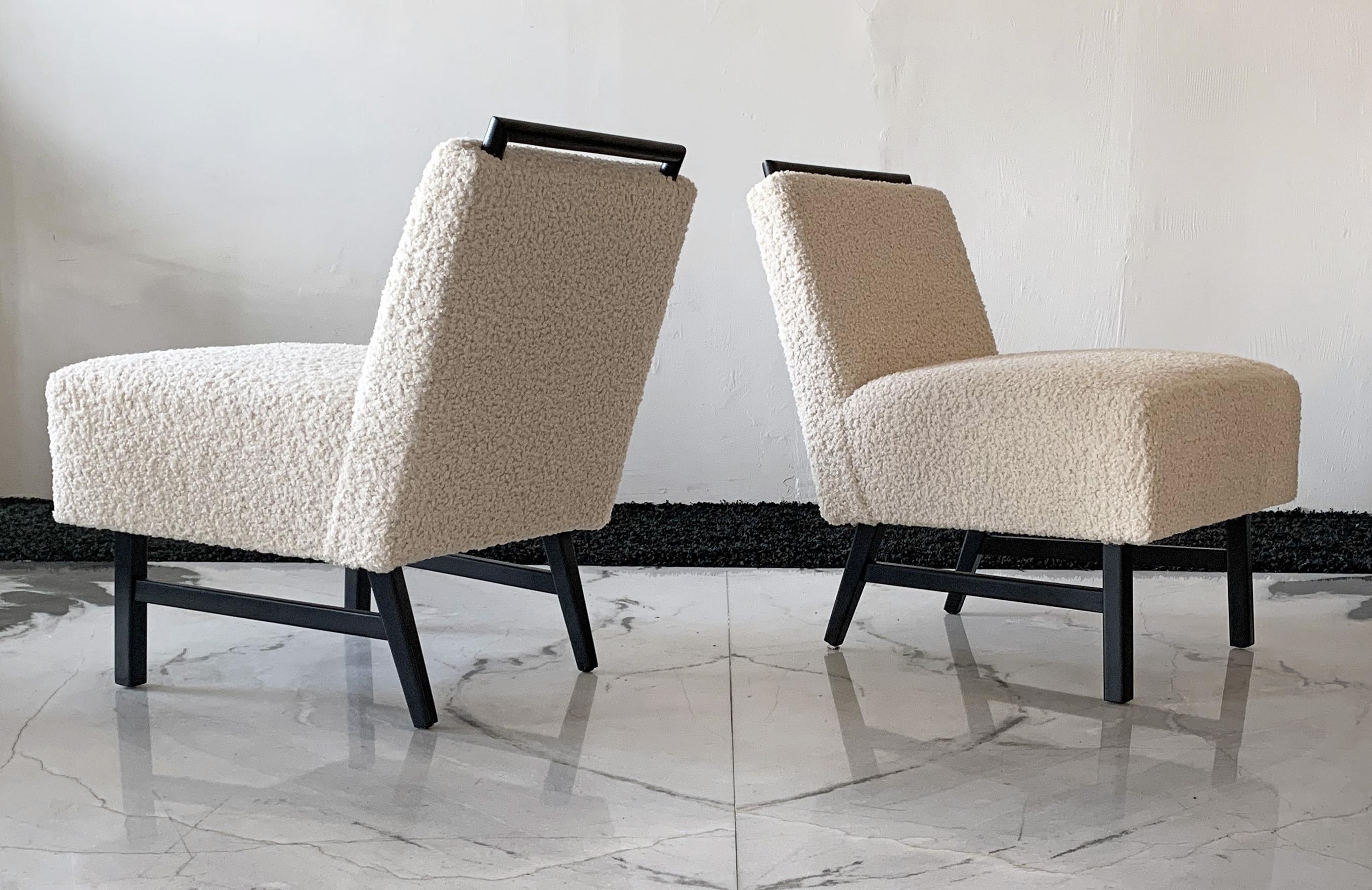 These chairs are simply stunning. These vintage slipper lounge chairs were designed in the 1950s in these style of Harvey Probber. These lounges have been ebonized and upholstered in a heavy off-white / bone bouclé that is incredibly soft to the