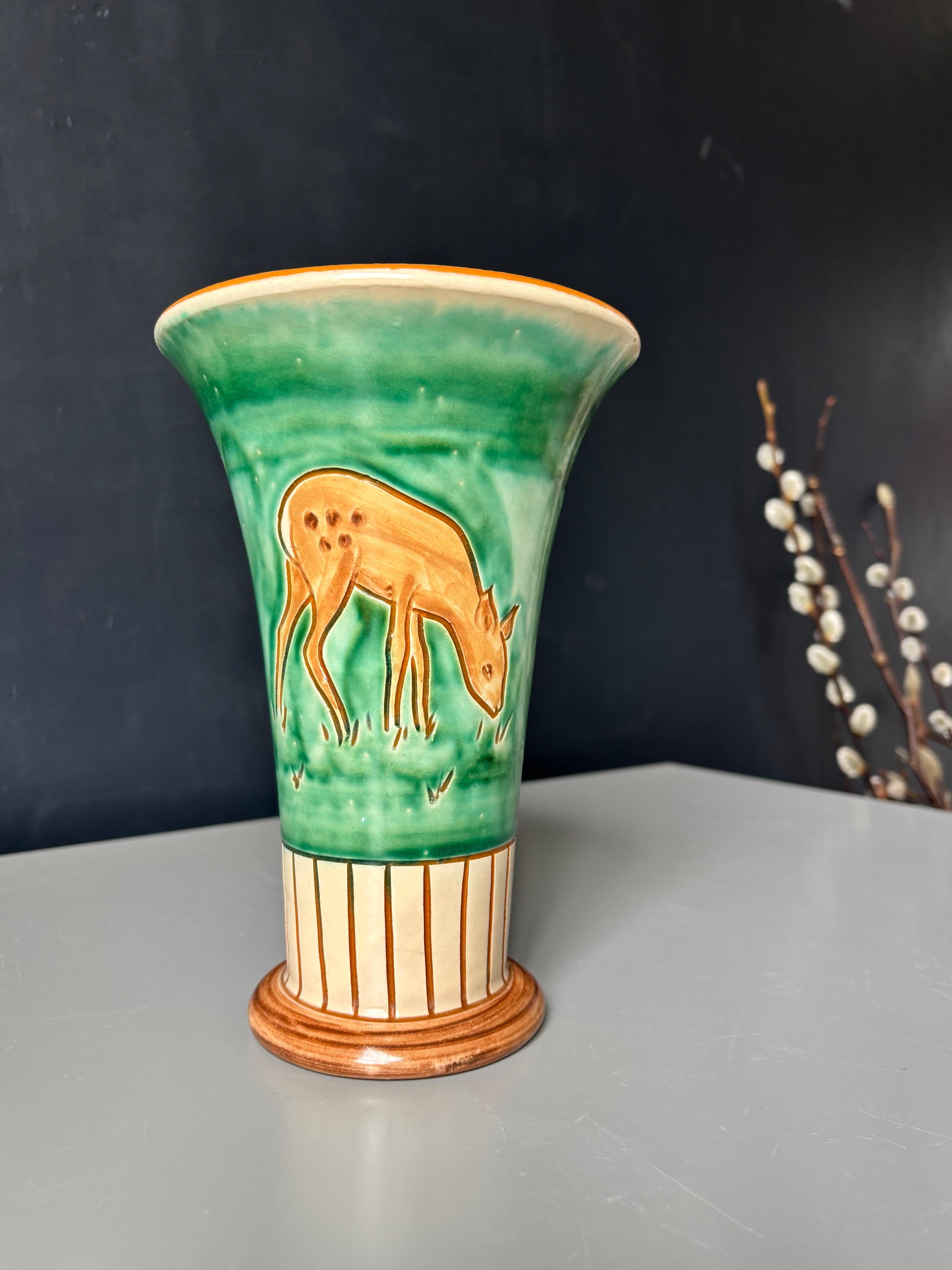 Handmade and hand-painted Danish midcentury organic modern ceramic vase by Haunsø in the 1950s. Incised lines on base and grazing deer motifs on body with green and cream colored glaze. 
Beautiful vintage condition. 
Denmark, 1950s.