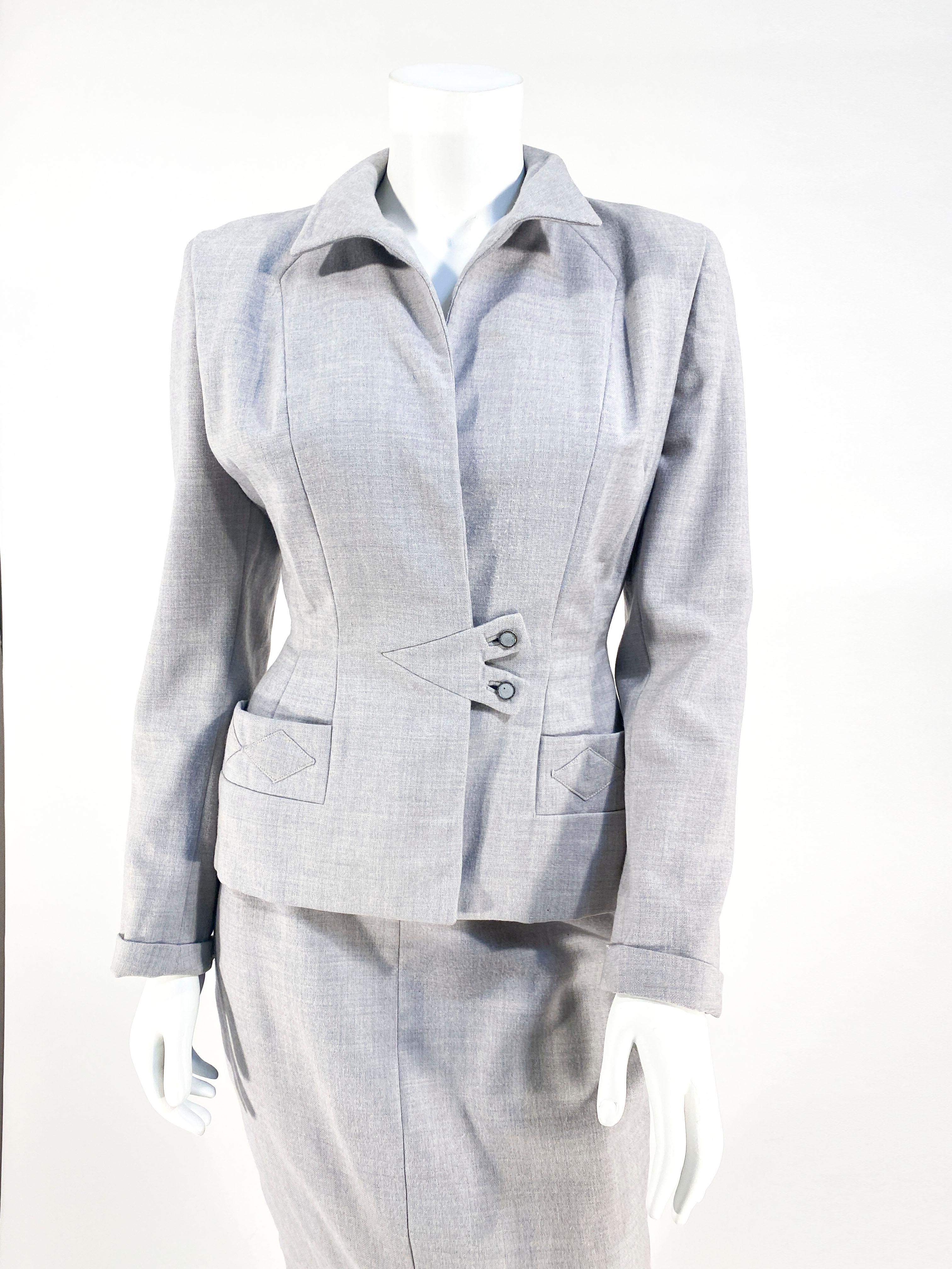 1950s heather grey wool suit with a Structured and pointed Peter Pan collar, front pockets decorated with diamond-shaped appliques, and a strictly waist closure for a tucked waist finished with grey and silver buttons. The matching straight skirt