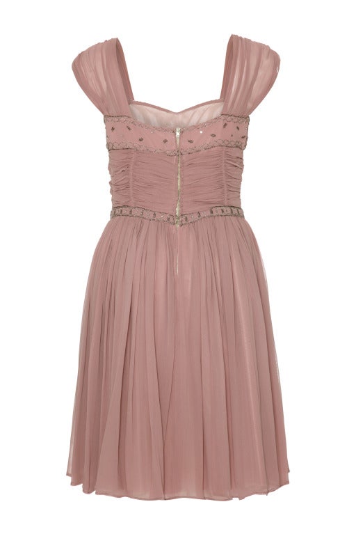 This lovely Heiress 1950s fine crepe occasion dress in dusky pink is pretty, gamine and features some gorgeous design details. The classic hourglass silhouette draws in neatly at the waist before flaring out over the hips into a playful knee length