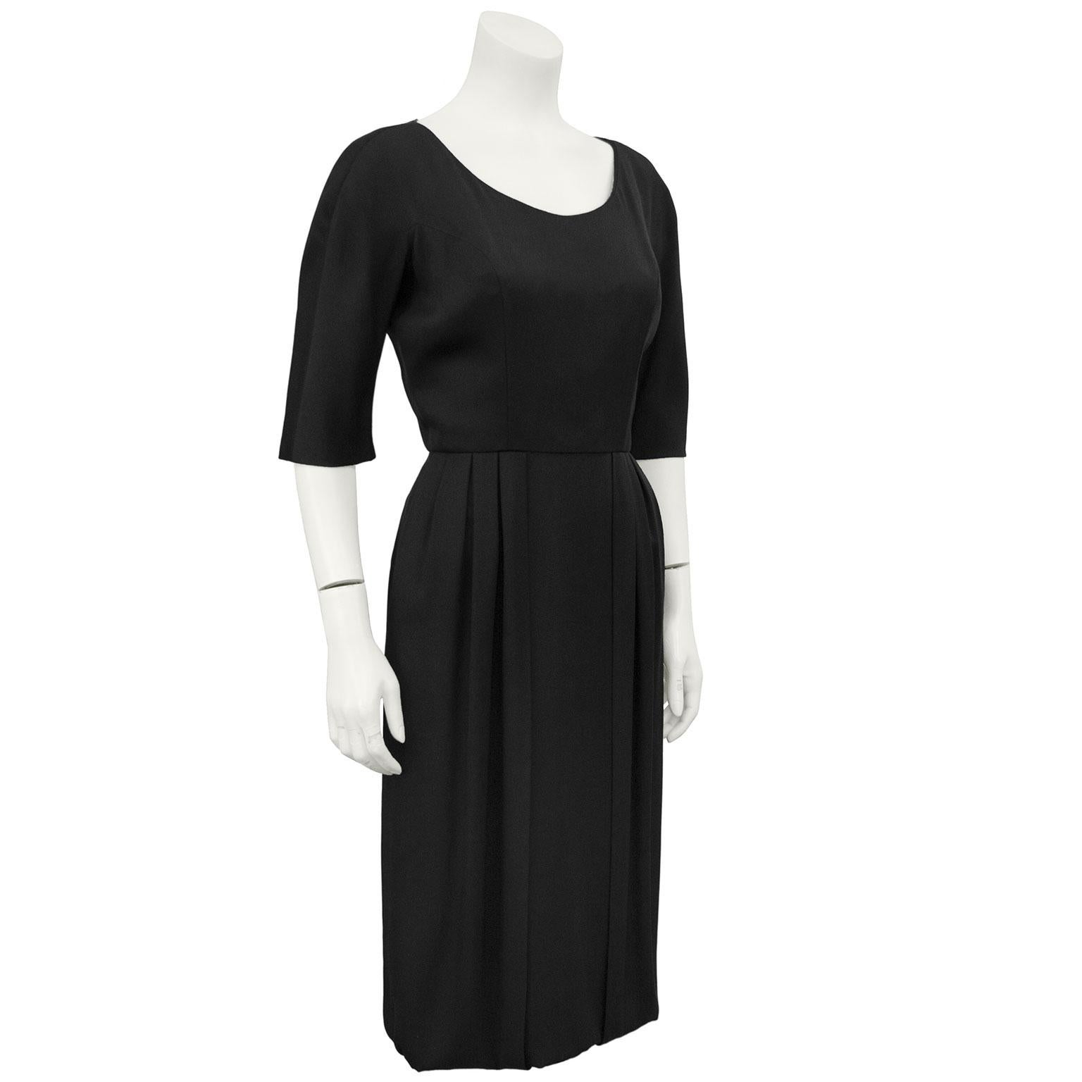 Beautifully constructed, this simple silk Helen Rose from the 1950's is the most classic LBD. The U neckline is balanced by the elbow length sleeves and seams down the sides of the bust. The pencil style skirt has a slight bubble hem and two pleated