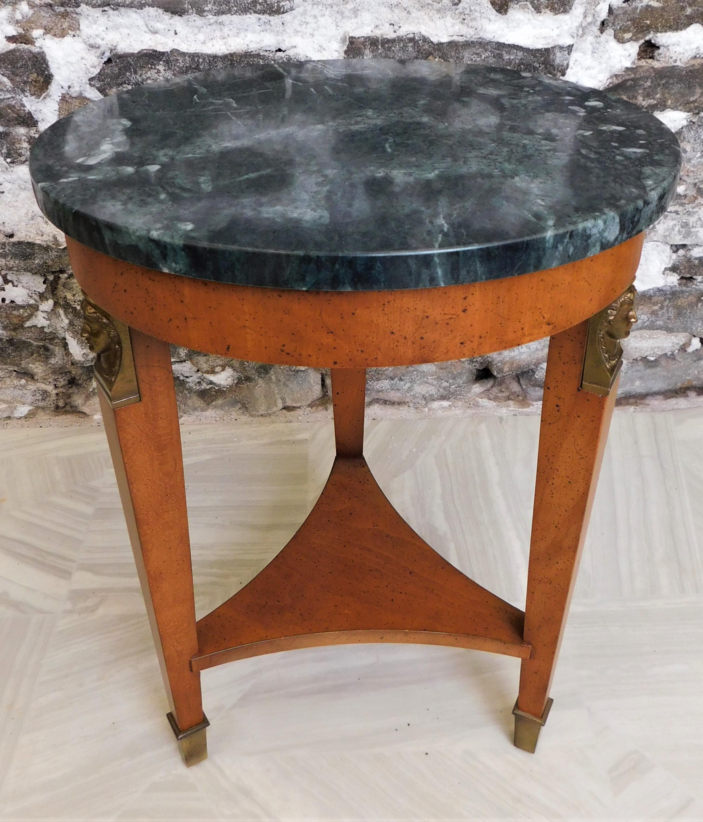 Beautiful 1950's Henredon fine furniture side or end table with brass capped feet on three legs and three brass figurative women's heads on top of legs and a made in Italy marble top. Nice Neoclassical or Empire styling.