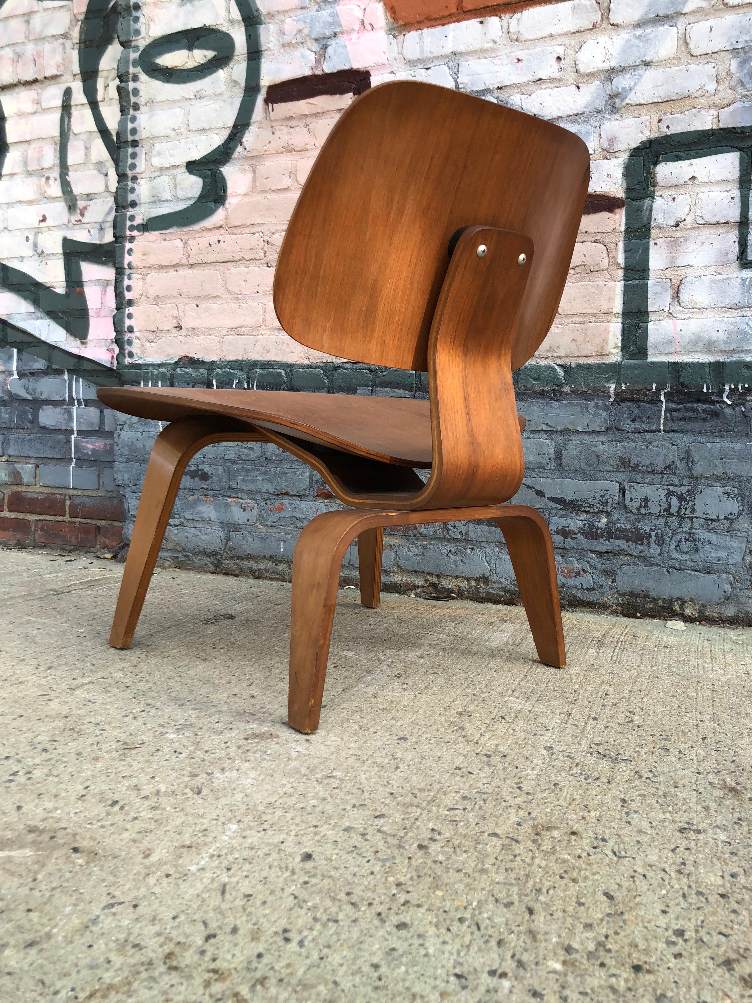 Eames LCW molded plywood lounge chair for Herman Miller. Gorgeous patina and color to the wood. Fit for regular use. Normal wear. Original back mount still very flexible with no hardness or dryness to the rubber Stamped LCW, dating to early