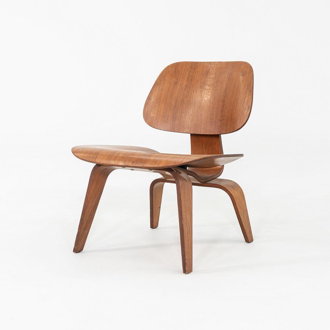 This is an LCW Lounge Chair, originally designed by Charles and Ray Eames in 1948. It is an early Herman Miller example featuring the 5-2-4 screw pattern. The chair is composed of walnut, and its age has only contributed to its beauty. The finish