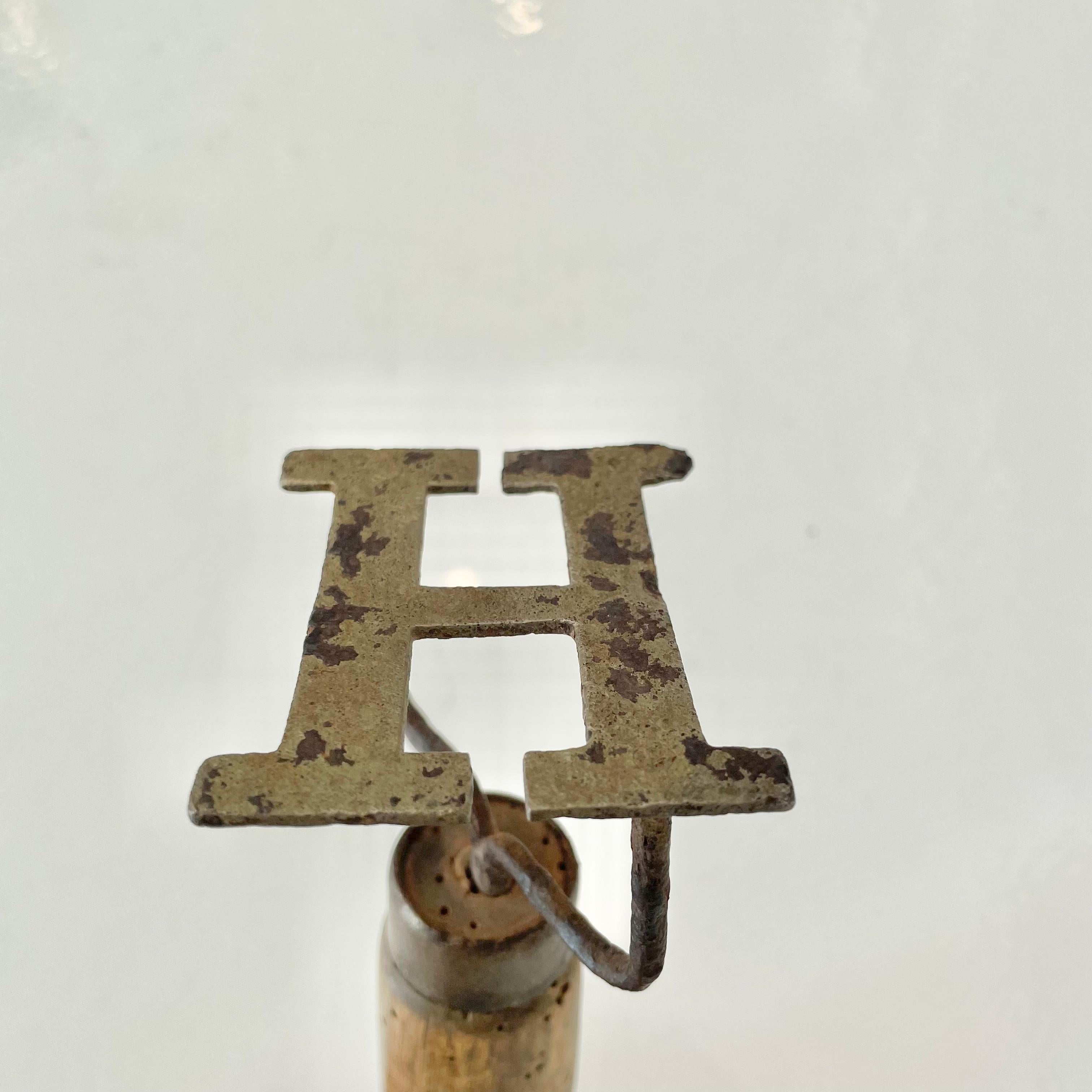 Handheld branding iron with Hermes H logo. Bought in France, likely used by ranch hands for branding hides. Unique piece that works great as desk art. Wooden handle and iron head.

 