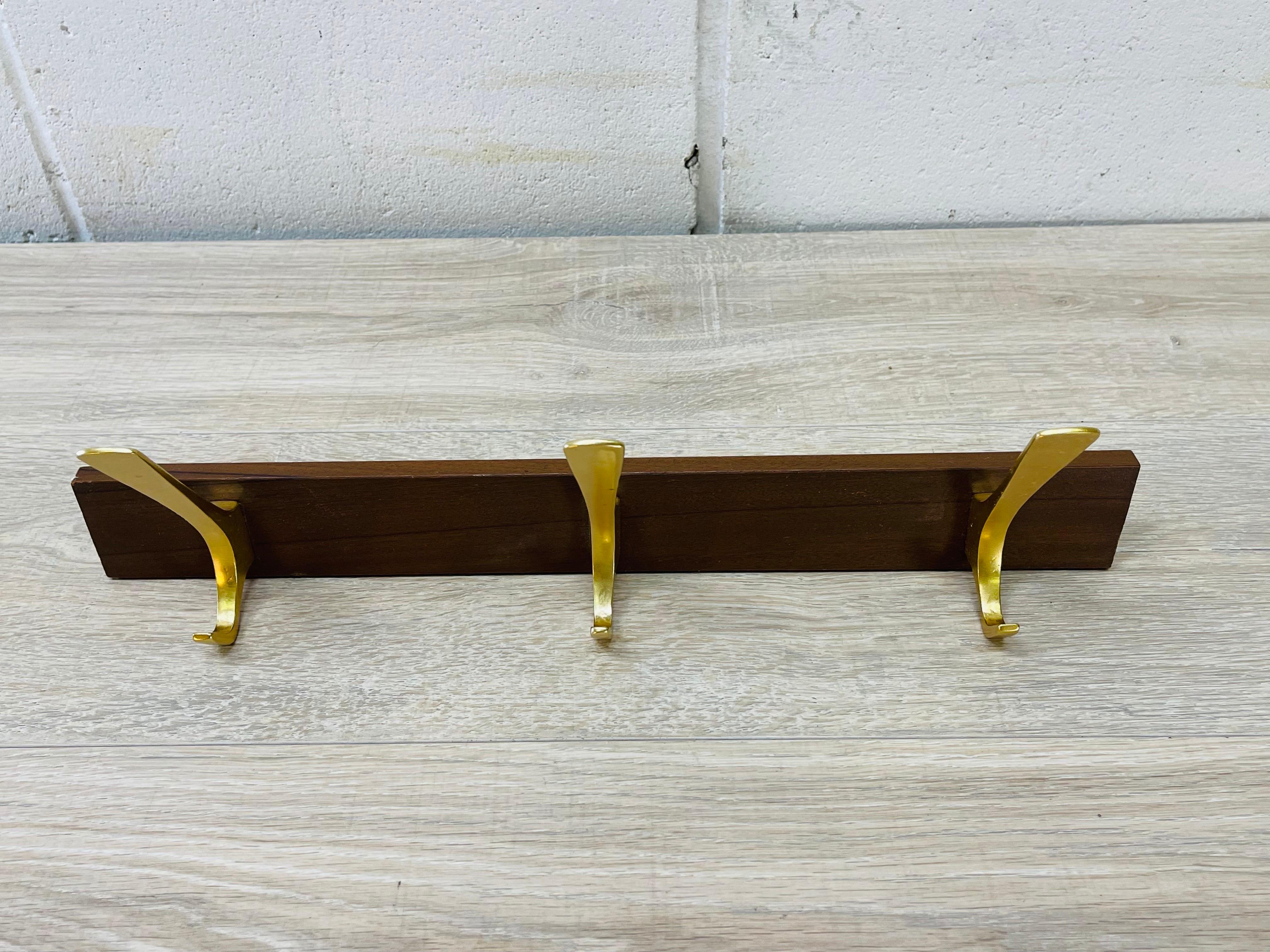 Vintage 1950s hertha baller austria wall mounted 3-Hook coat rack. The wall coat rack is made of walnut wood with the brass hooks. Hardware is included. No marks.