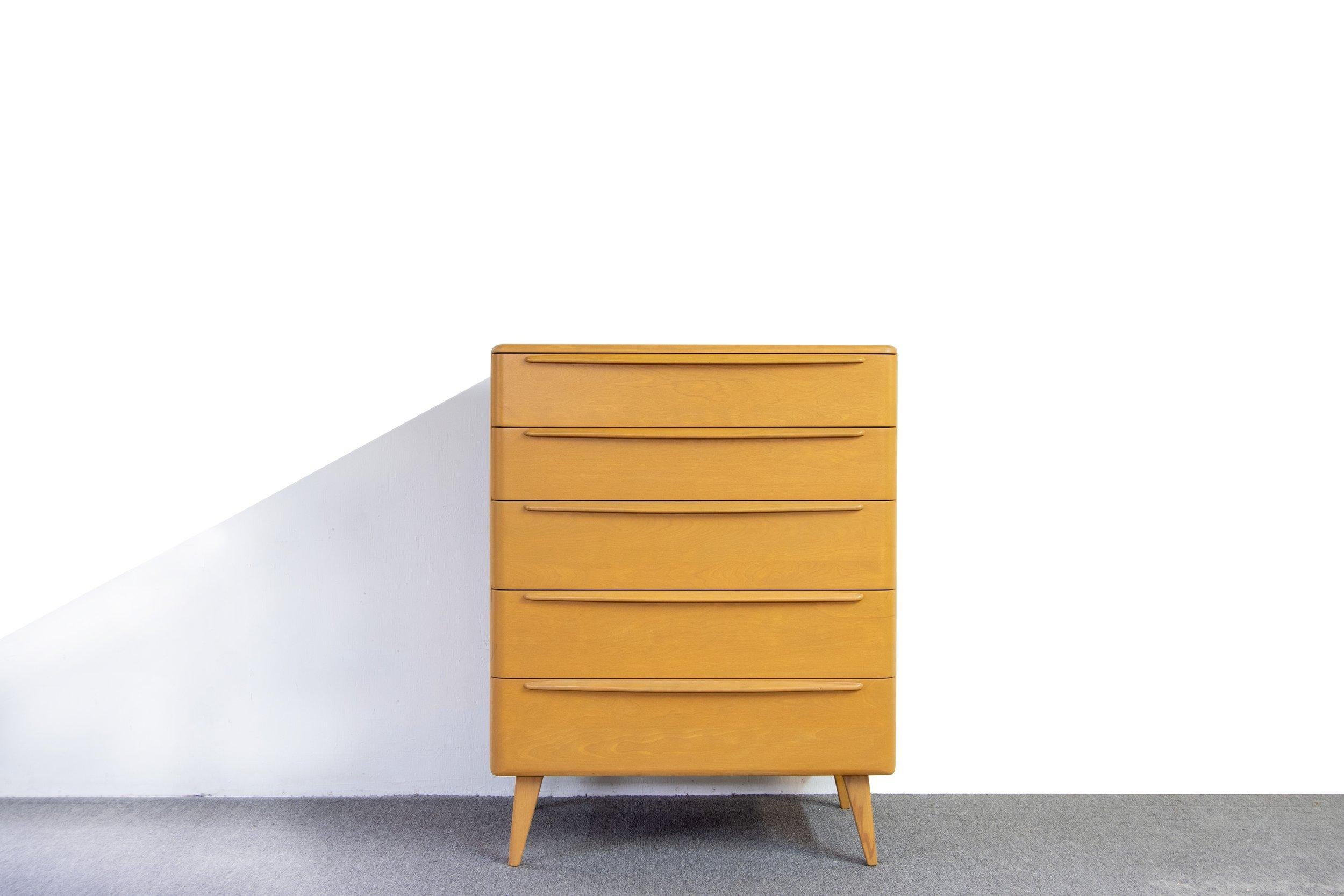 An exceptional 1950s, Heywood Wakefield Encore 5 drawer high boy dresser in a beautiful wheat color.   Great rounded edges with elongated drawer pulls that span the width of the drawers. This piece was stripped and professionally refinished with a