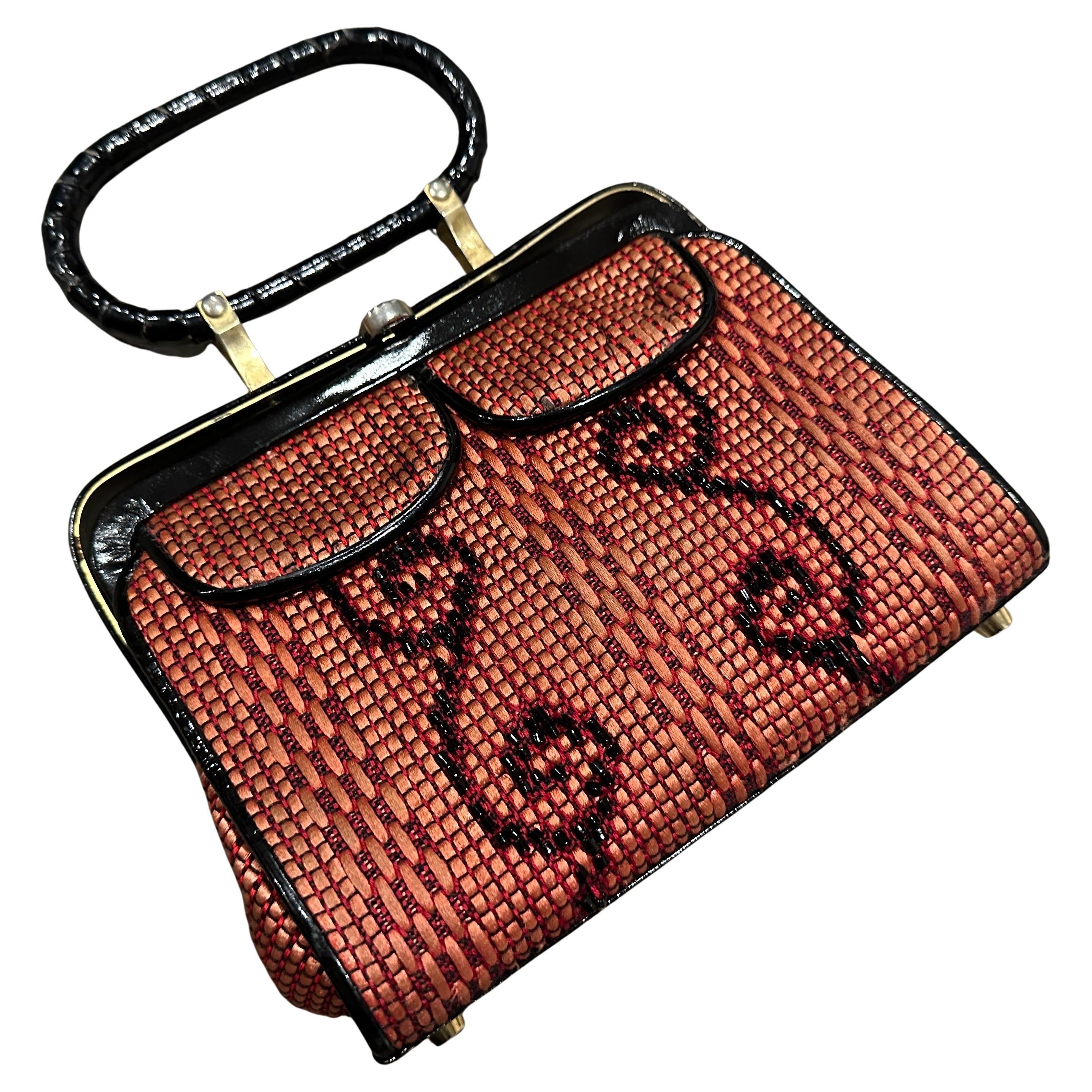 This is a vintage 1950s high-quality Italian top-handle bag, featuring an elegant and intricate woven design. The bag is crafted from a combination of materials, lincluding wicker in a warm reddish-brown hue, accented with black details in a
